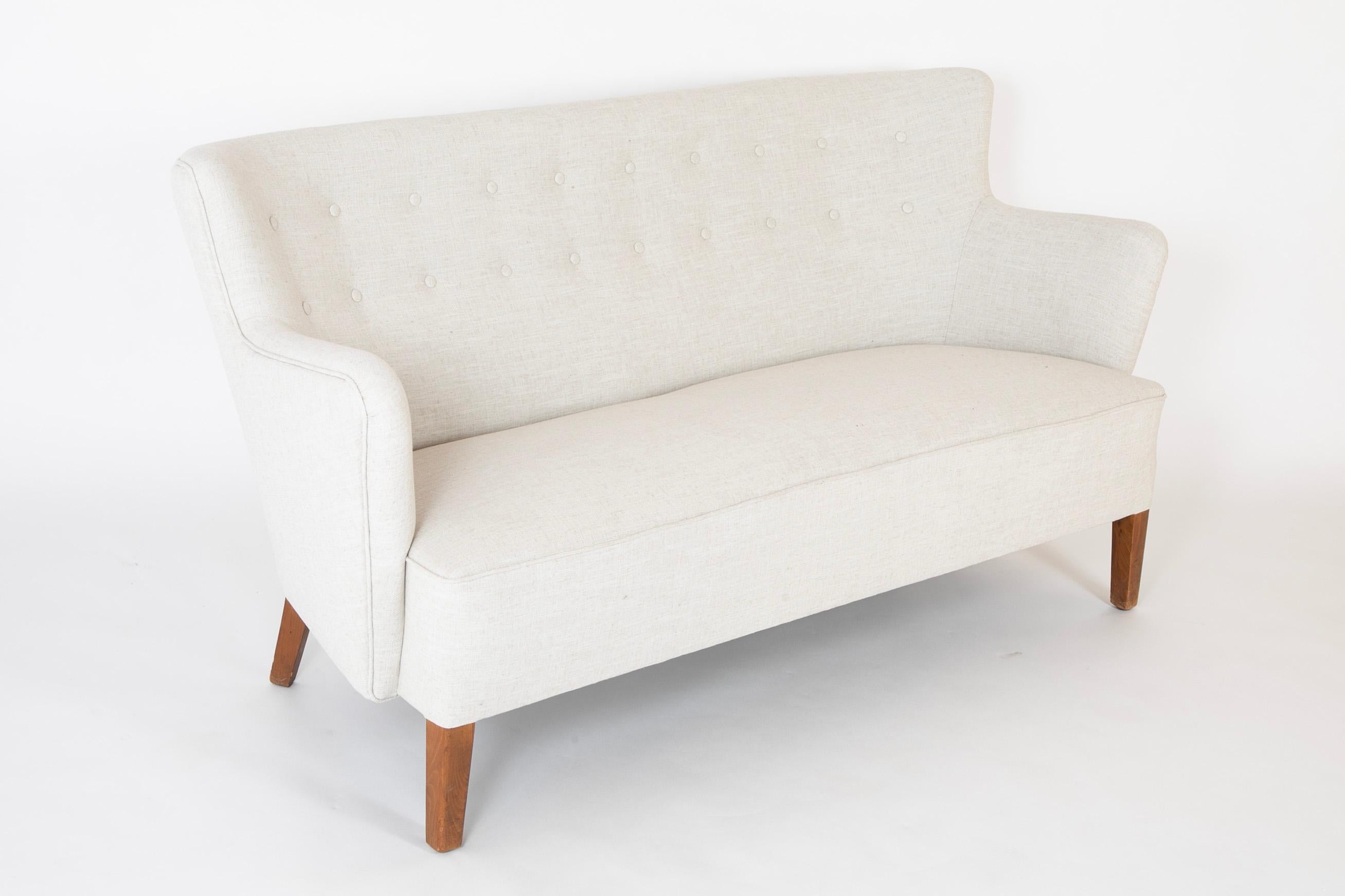 Mid-Century Danish love seat with stained beech frame.  Newly upholstered with button fitted back.  Circa 1930 - 40's.