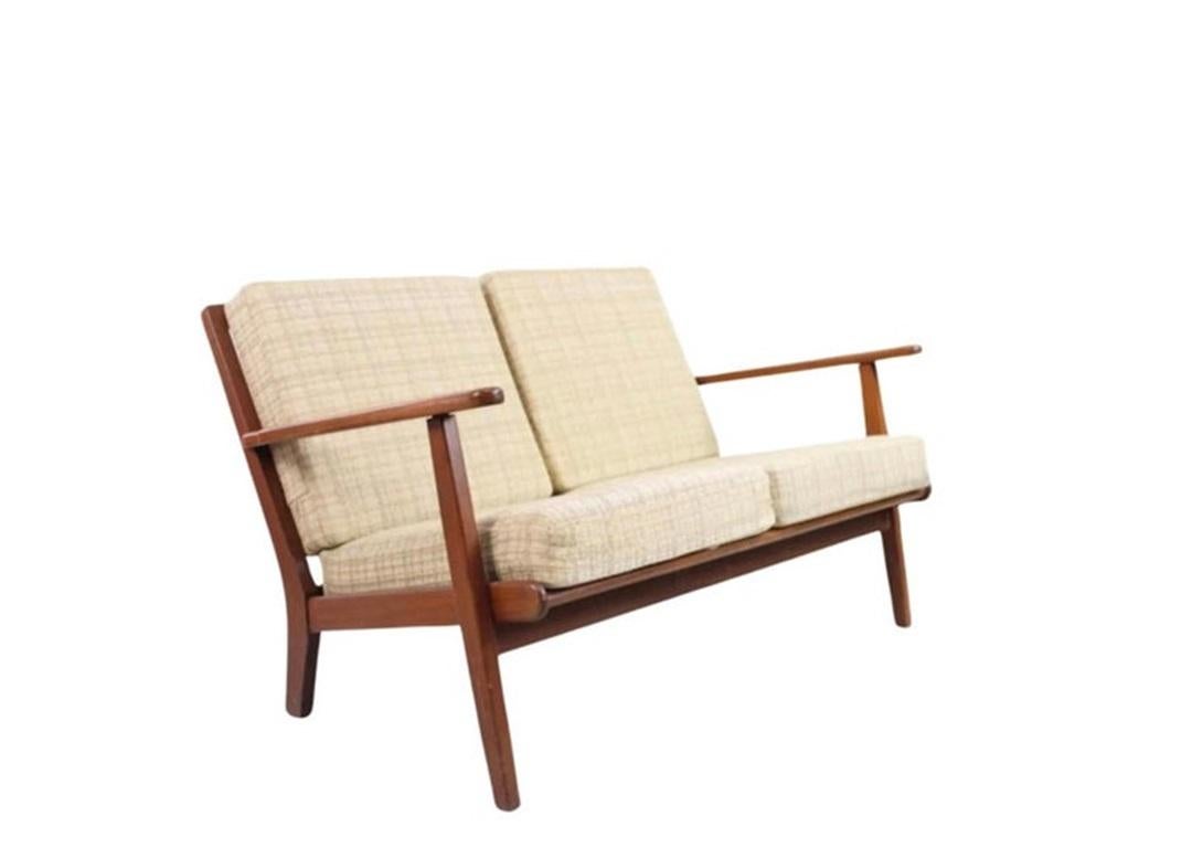 Sofá moderno danés de 2 plazas de Aage Petersen para Getama Model No. GE88. Este sofá de 2 plazas tiene una estructura minimalista de teca con patas traseras en ángulo y respaldo de listones de madera. Tiene cojines de tela escocesa color avena. El
