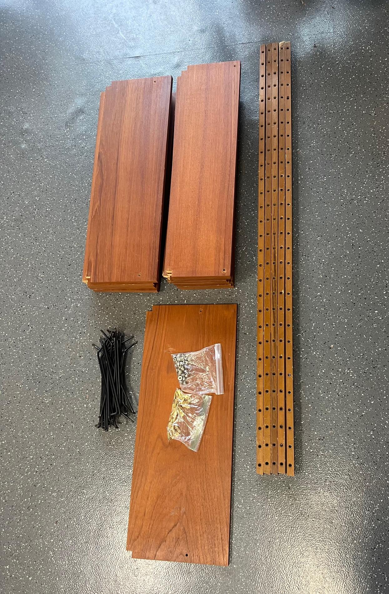 This is a stunning mid century teak shelving system. Made in Denmark. Similar to Cadovius units.

It is a modular unit. You can arrange it in many different ways.

It consists of 5 poles and 15 shelves, All hardware included.

Very good vintage