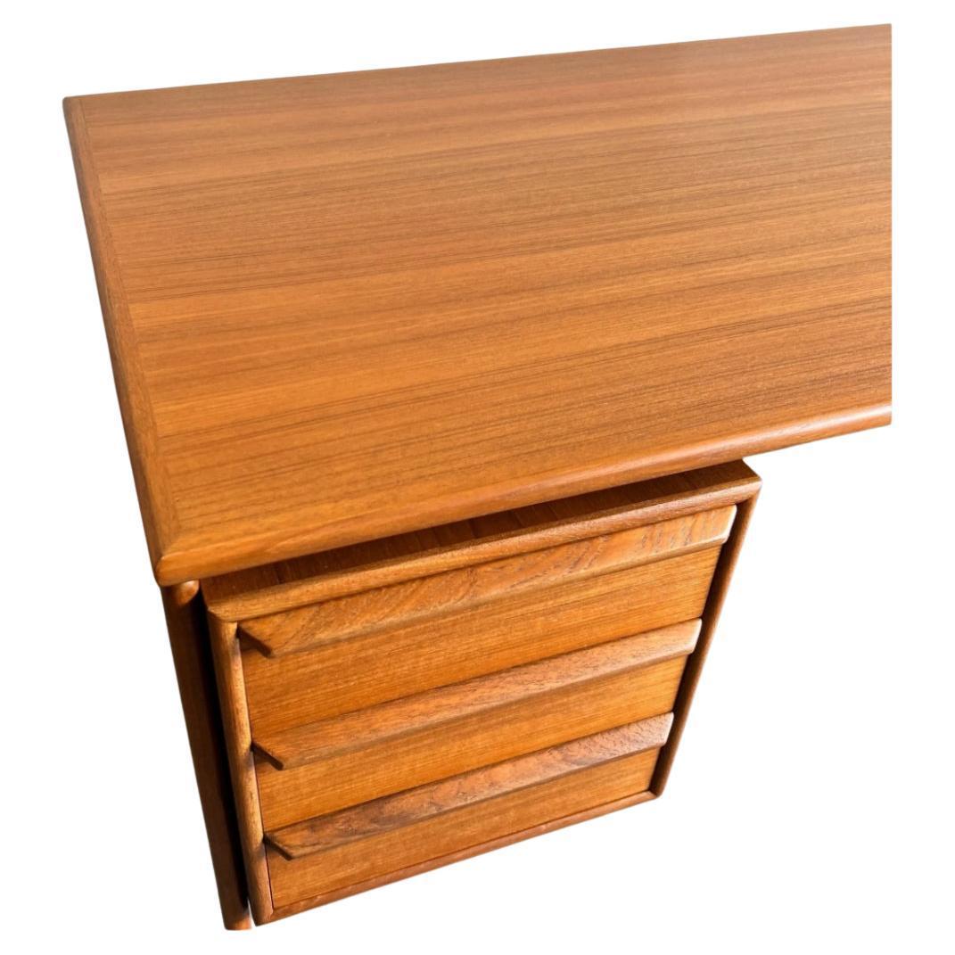 Metà secolo, moderno danese G.V. La scrivania in teak Møbler vanta un piano galleggiante di grande effetto con tre cassetti a coda di rondine a sinistra e un profondo cassetto per cartelle a destra. I cassetti sono caratterizzati da eleganti tiretti