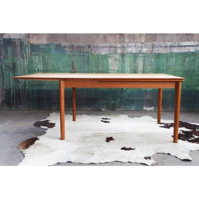 Beautiful large, extendable Danish Mid Century teak table with draw leaves that tuck under when not in use. The table is in excellent shape. It is made by Ansager mobler. It is in excellent condition, and the beautiful and consistent colored teak