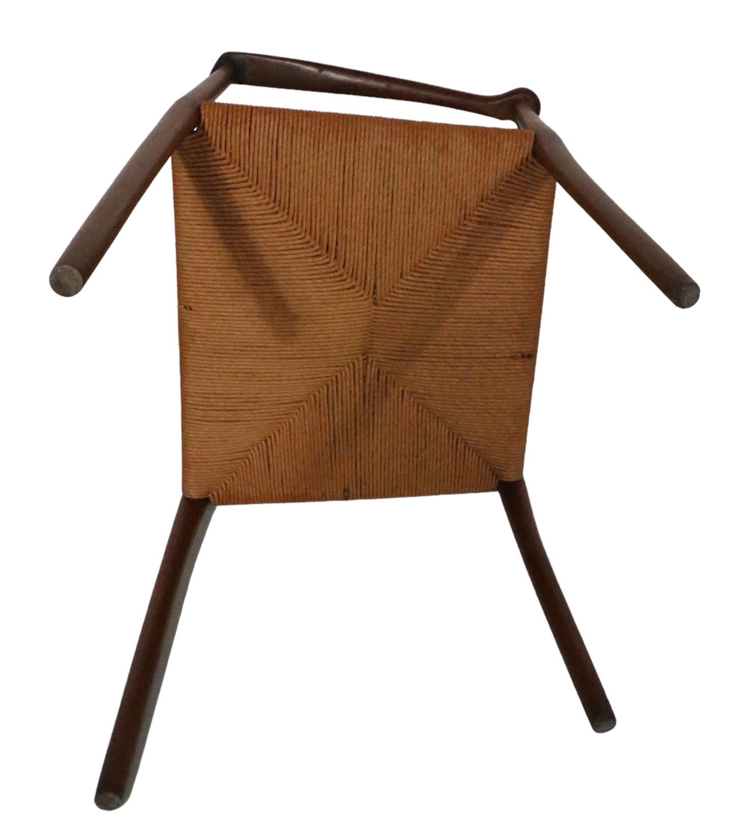 Architectural Danish Mid-Century Modern constructed of solid walnut with a rope seat. The chair exhibits the expected attention to Craft found in high end level Danish woodwork, we are not sure who made or designed the chair, and it is unsigned. The