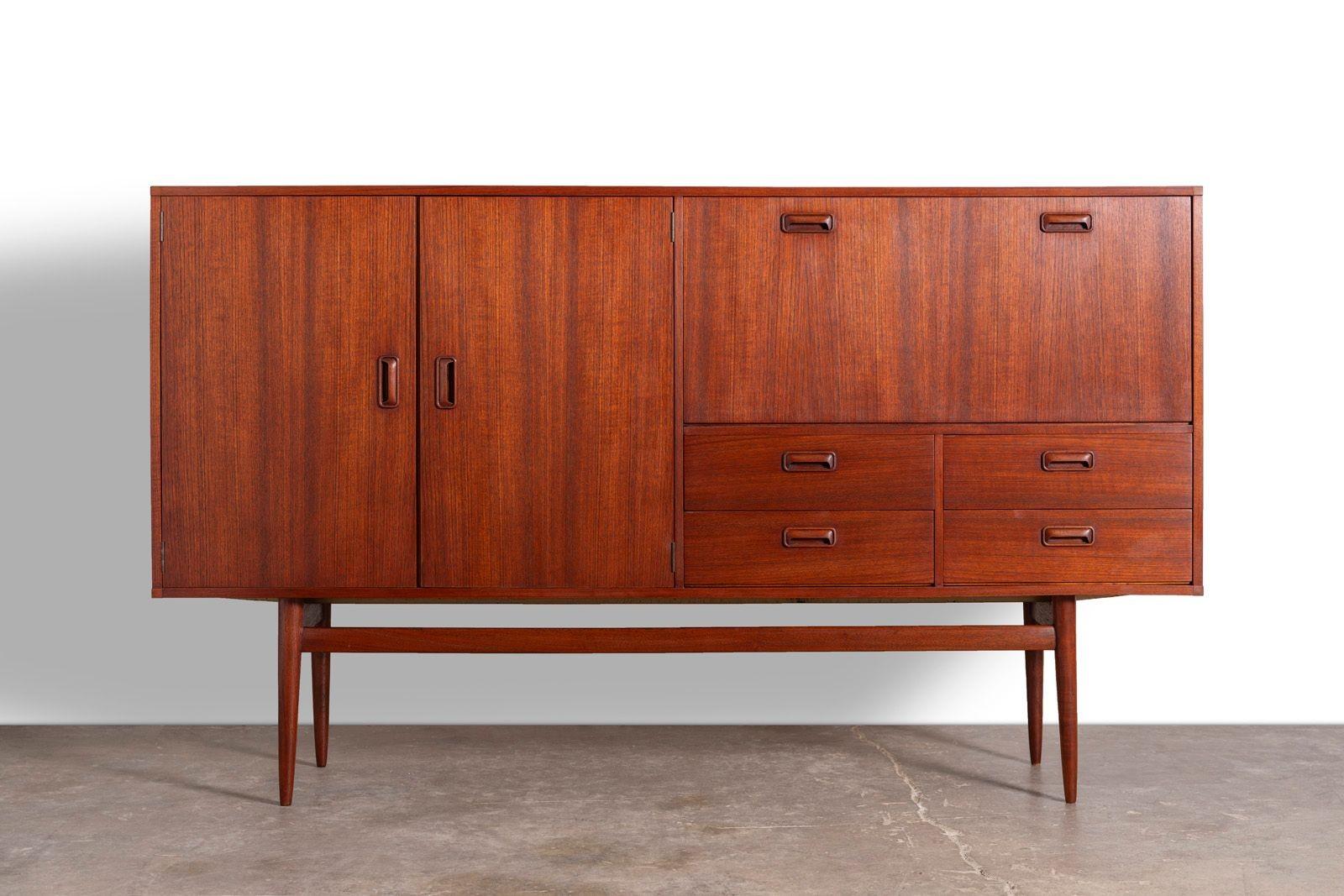 The right side of the cabinet features a drop-front door that opens to reveal a dry bar with an illuminated shelf, perfect for showcasing cocktail and wine glasses. A thoughtful cutaway in the shelf accommodates your favorite bottles of spirits,