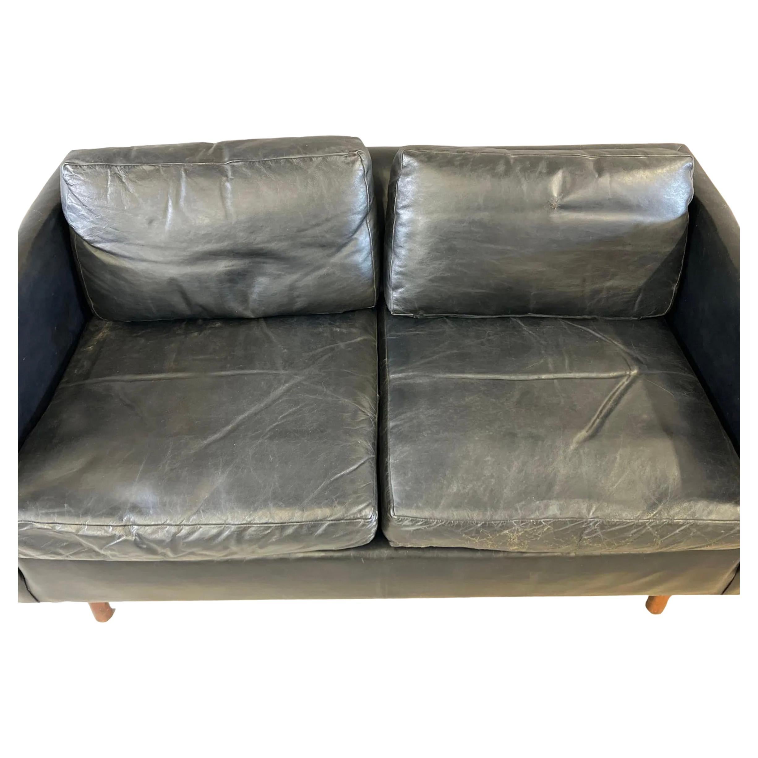 Midcentury Danish modern beautiful Black leather 2 seat loveseat sofa with teak legs. Beautiful Black leather is soft and shows little signs of use but broken in nicely. Great small Danish Modern sofa. Great vintage condition. Sofa is made in