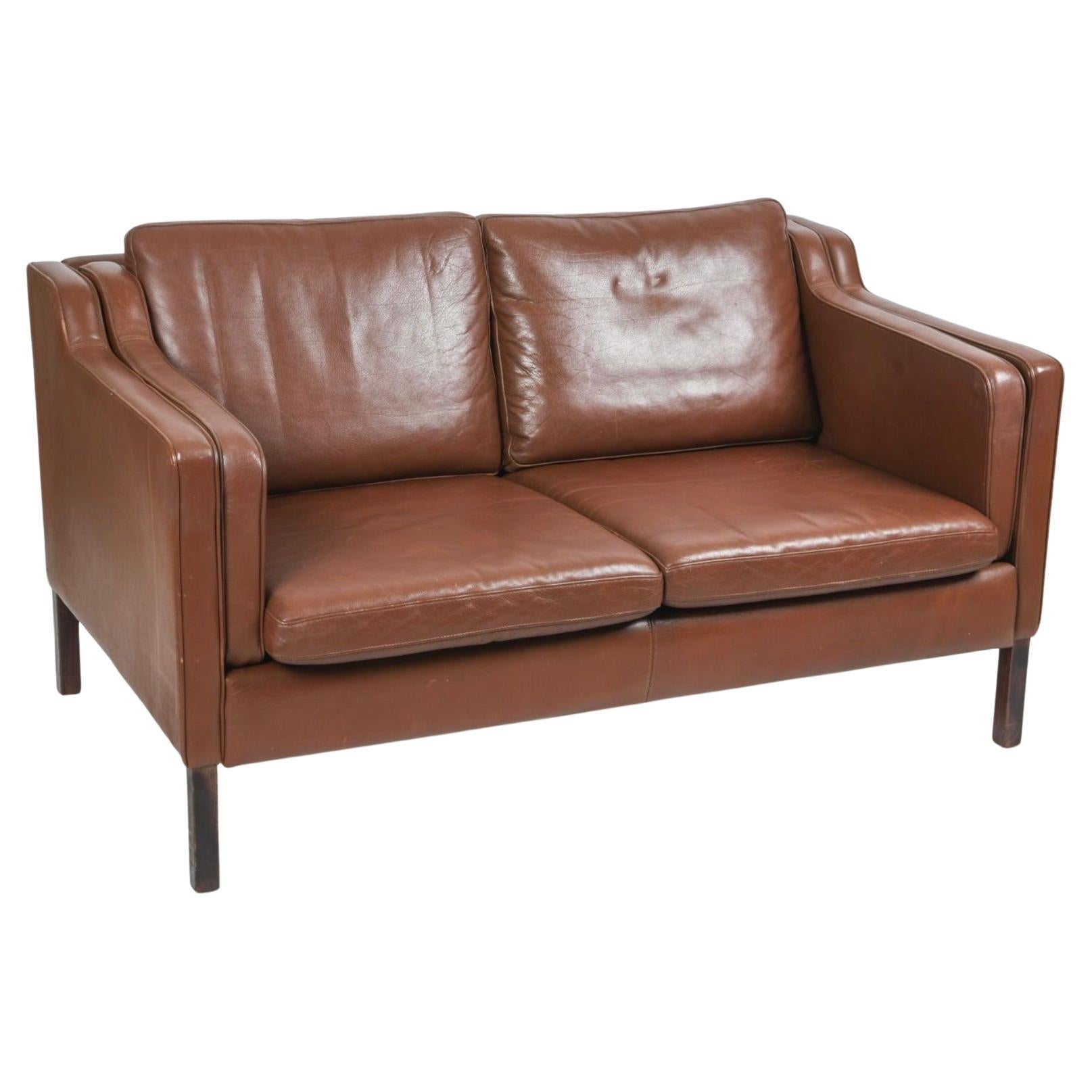 Mid century Danish modern beautiful Brown leather 2 seat sofa Dark brown wood legs. Style of Børge Mogensen. Beautiful Brown leather is soft and shows signs of use but broken in nicely. Great small Danish Modern sofa has original down filled