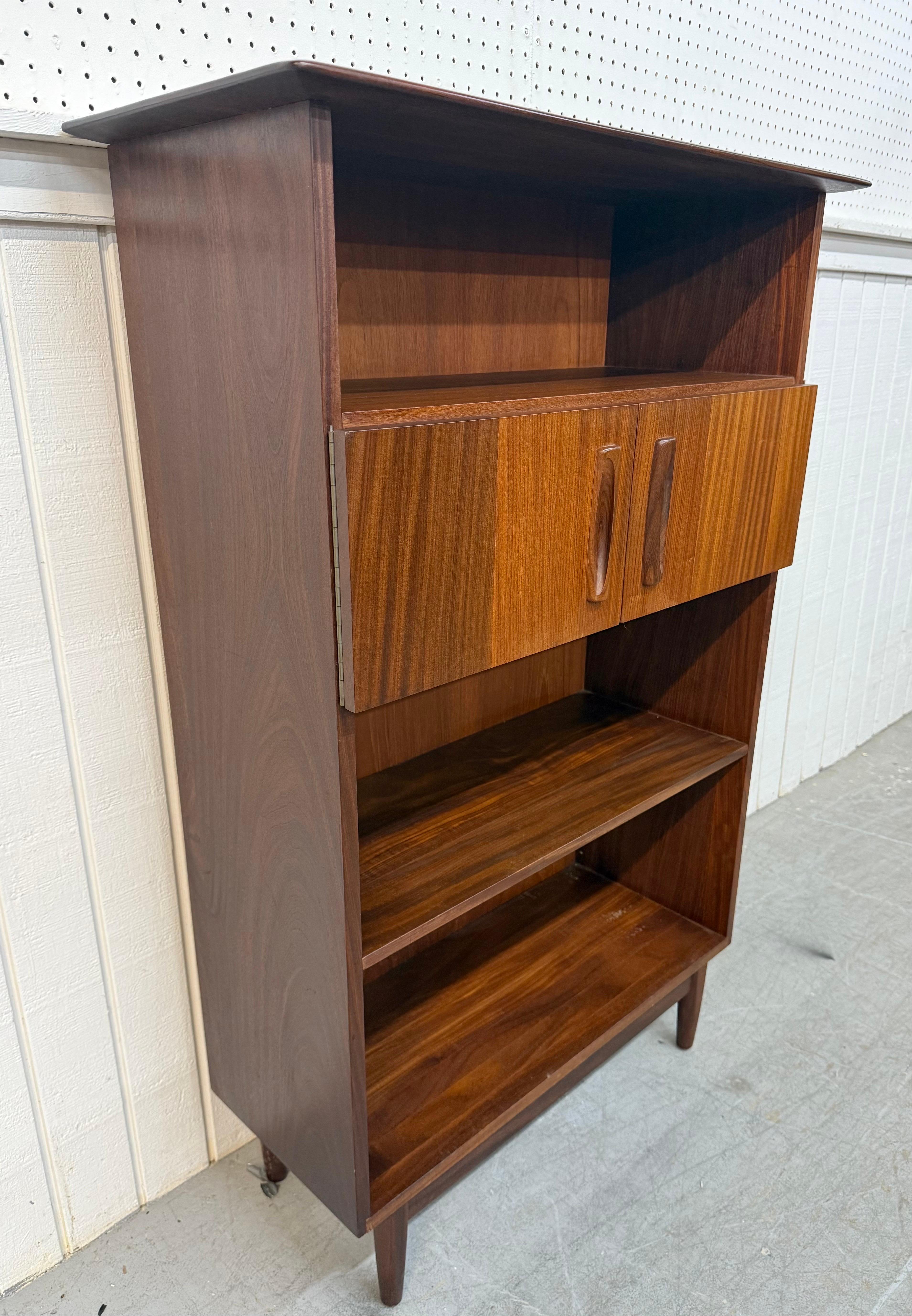 Questo annuncio si riferisce a una libreria moderna danese di metà secolo. Il design è lineare, le due ante si aprono grazie a dei tiretti in legno, i quattro ripiani per riporre gli oggetti, le gambe moderne e la bella finitura in noce. 