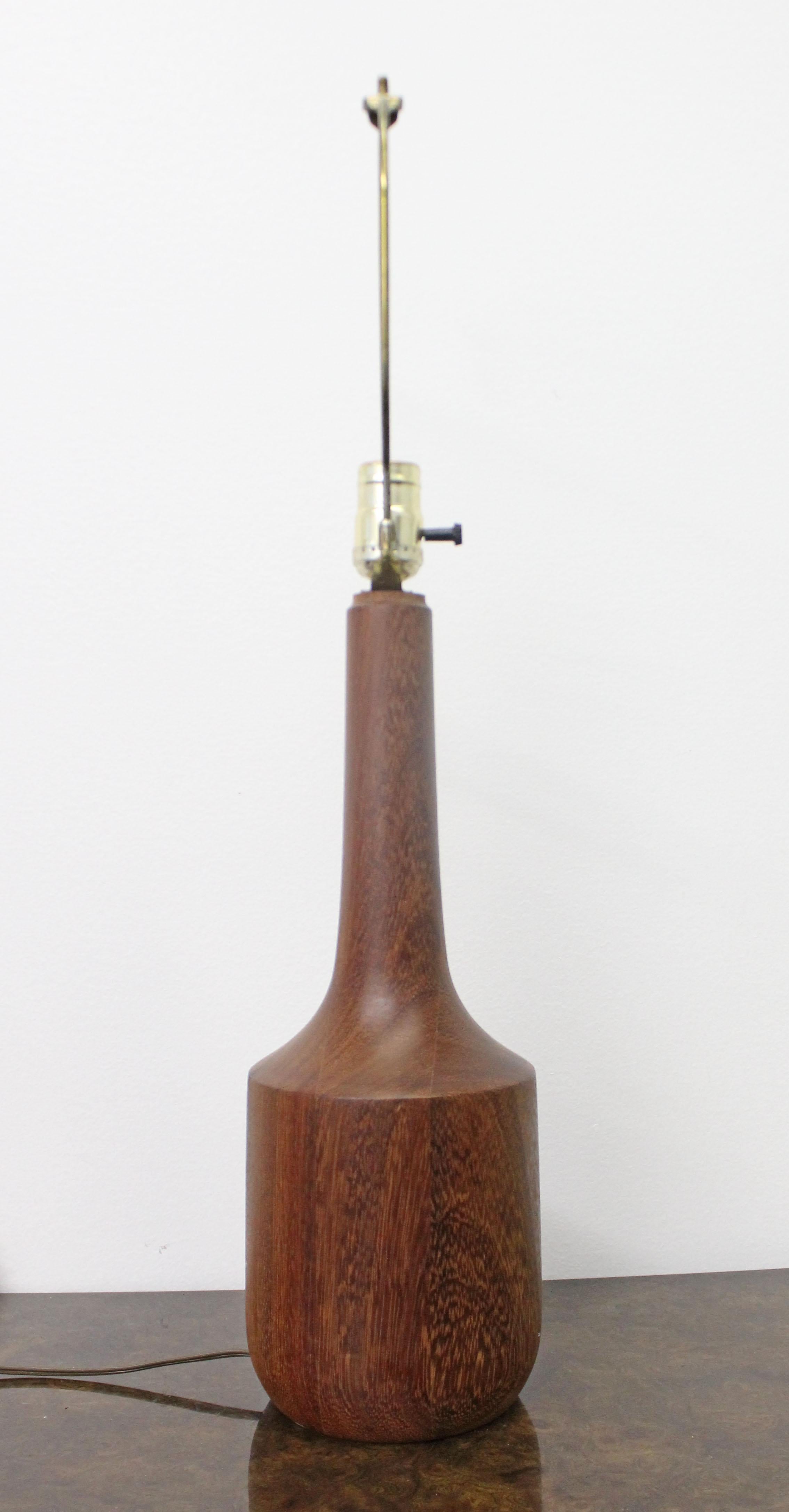 Offered is a bottle shaped vintage Danish modern teak table lamp. It is in good, working condition with small surface scratches on the wood and age wear on the brass. It is not signed. A great piece to add to any room in your home.