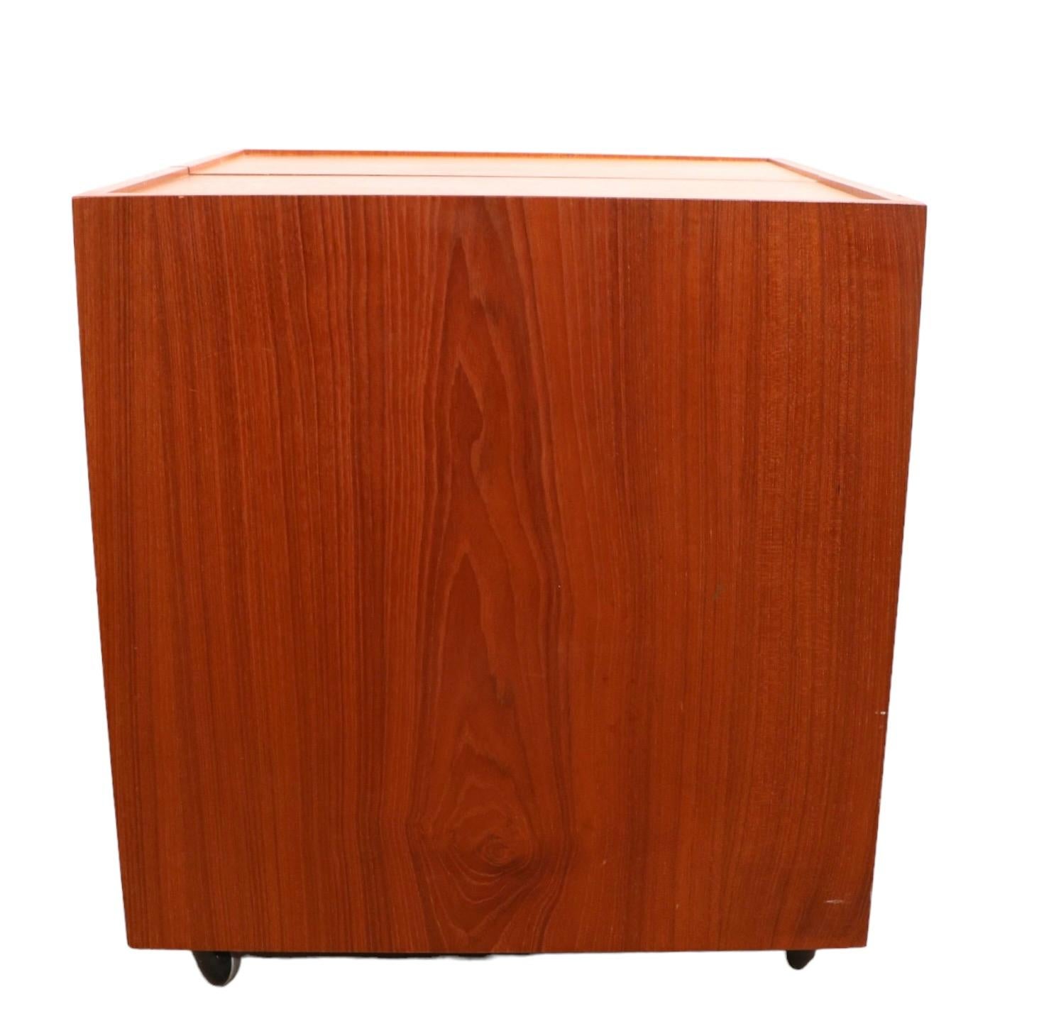 Chic collapsible cabinet bar designed by Erik Buch for Dyrlund, made in Denmark circa 1960- 1970's. Te cabinet feature twosomes, which open to storage, and pullout work surfaces. The interior surfaces have a laminate covering to make clean up