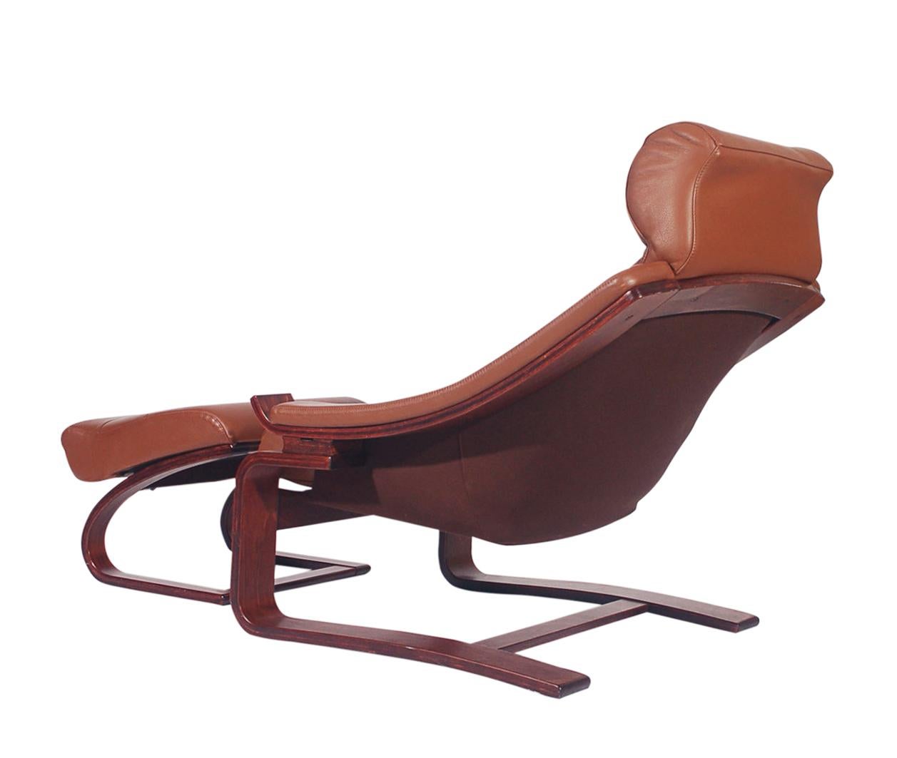 A super chic leather lounge chair and ottoman from Norway circa 1980s. This chair features solid rosewood stained wood construction with gorgeous cognac leather upholstery. Marked: NORWAY - Very well cared for and in very good condition.