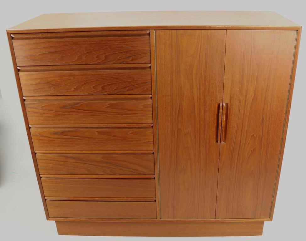 Very nice Danish modern gentleman's wardrobe chest in solid teak, and oak by Westnofa. This stylish dresser features a tall bank of seven drawers flanked by two doors which open to reveal seven interior drawers. Great original, clean ready to use