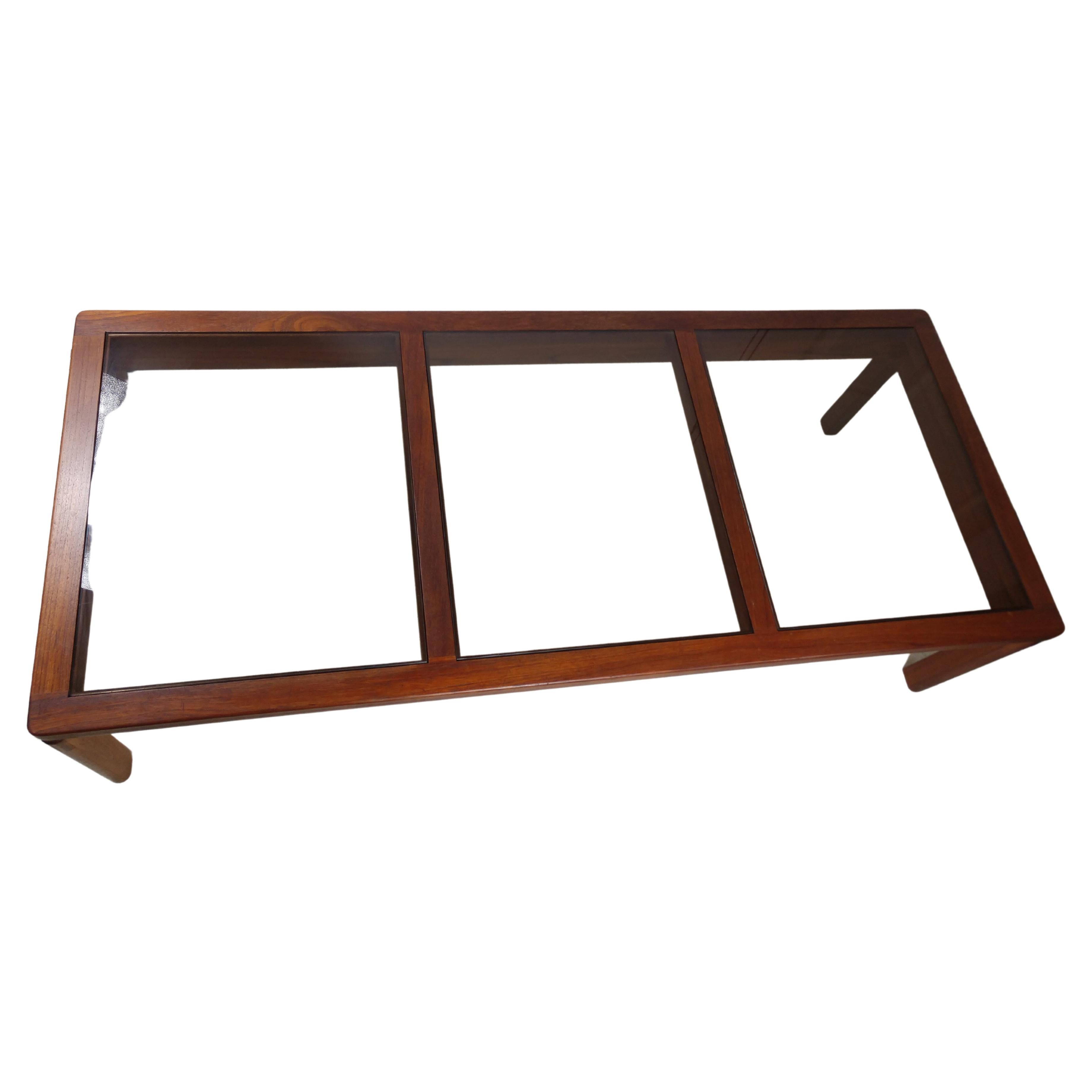 Simple and elegant 3 panel smoked glass cocktail table with architectural spacing and large ship lap dovetail joints. Rounded legs that square off. In excellent vintage condition with minimal wear. Panels of glass lift right out and can be change to