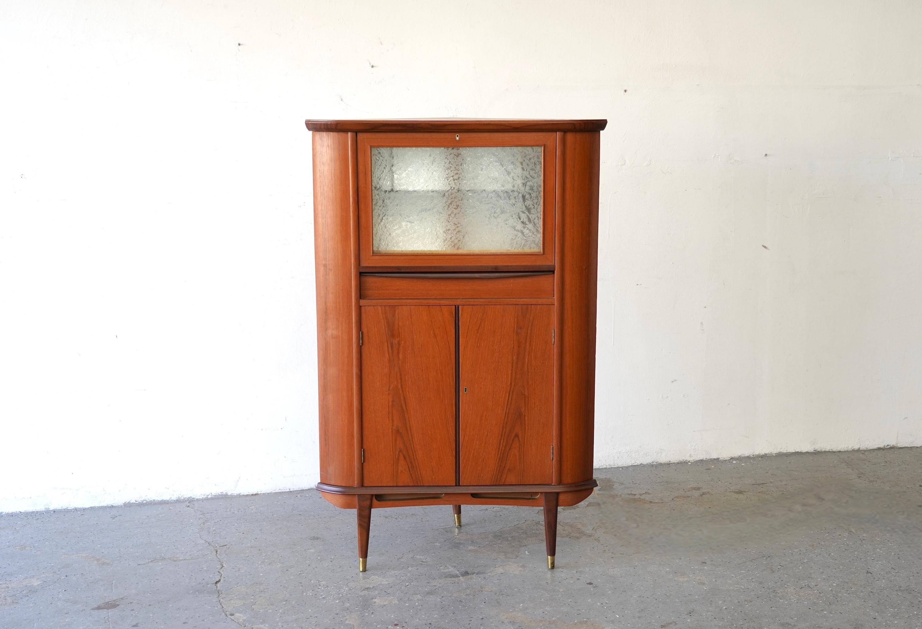  Eleganza classica: metti in scena il tuo James Bond o Don Draper interiore

Entra in un mondo di raffinatezza con questo raffinato mobile cocktail bar angolare in stile danese moderno. Realizzato in ricco teak con eleganti accenti in palissandro,