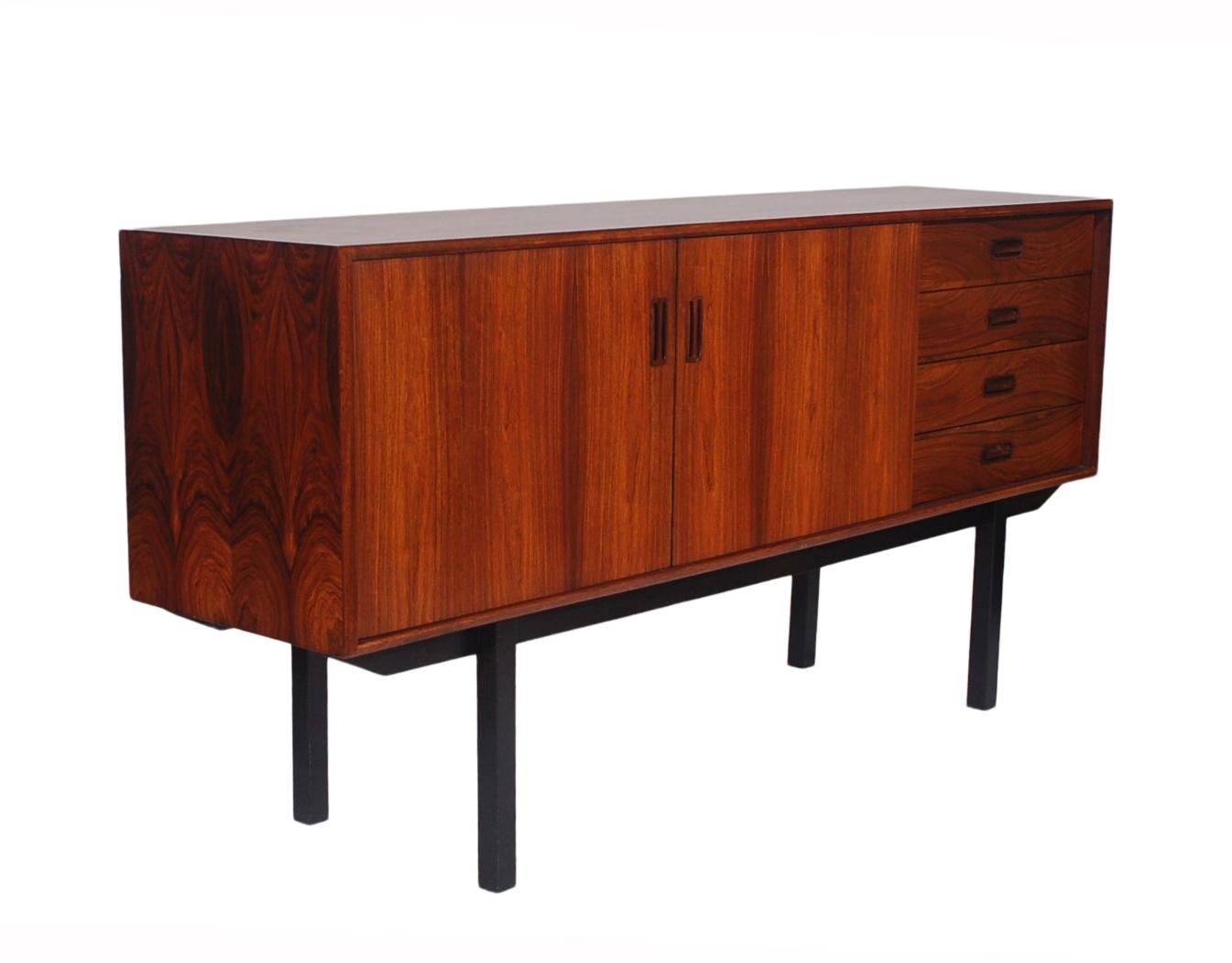 A handsome tall legged sideboard from Scandinavia circa 1970s. It features tall ebony legs with a gorgeous rosewood case. Clean condition with ample storage.