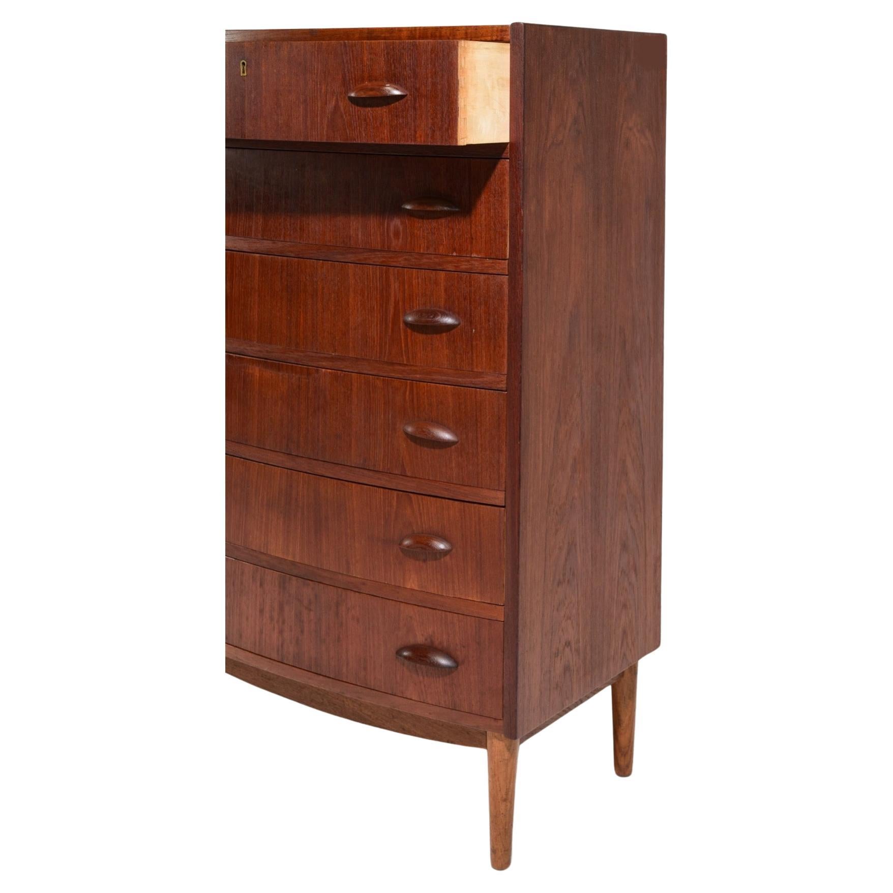Mid century Danish modern curved front 6 drawer teak tall dresser. Great teak dresser with classic Danish design has carved teak handles on (4) tapered legs. Made in Denmark located in Brooklyn NYC.

Measures 28” x 18” x 44” high