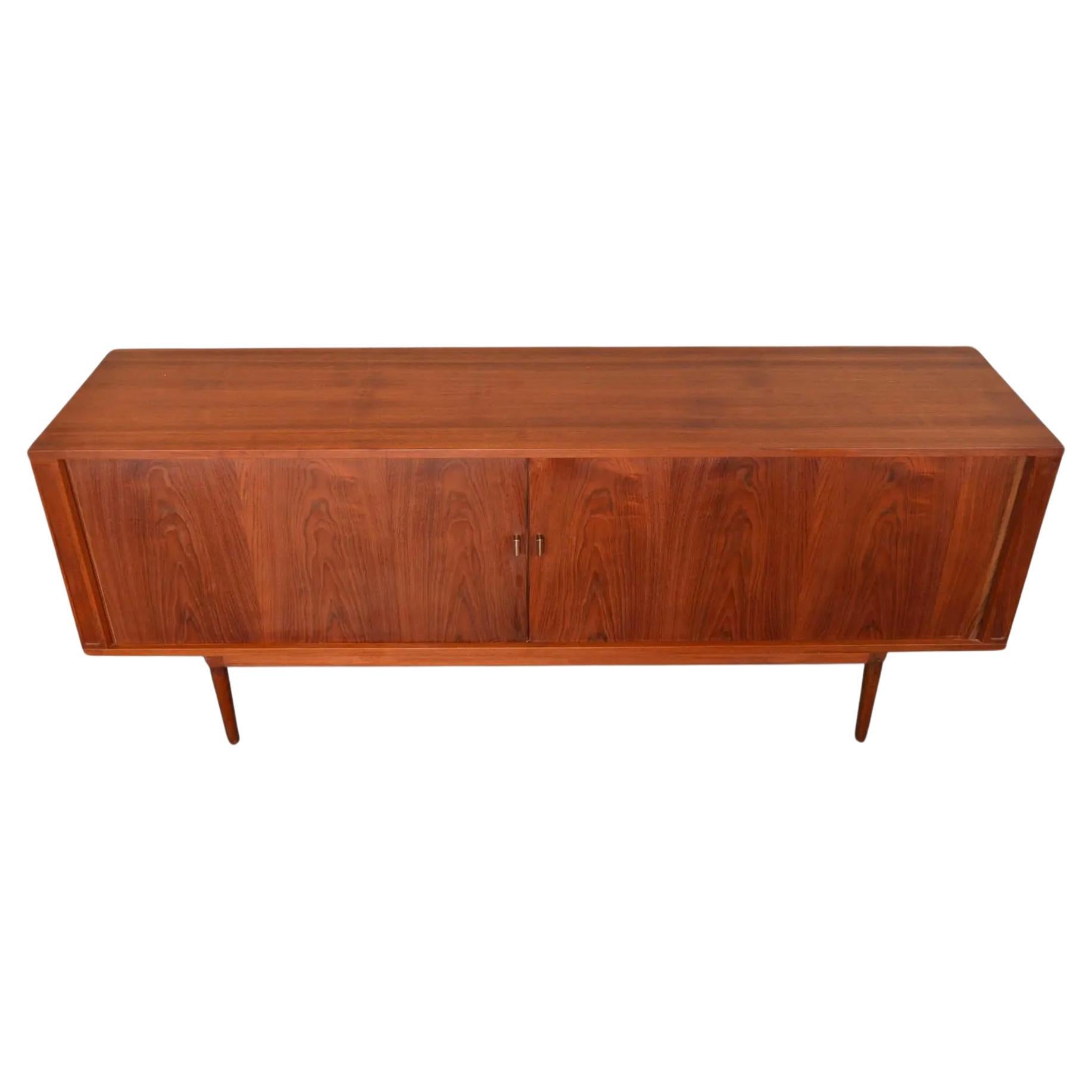 Diese schöne, lange Teakholz-Credenza von Peter Løvig Nielsen aus der Mitte des Jahrhunderts hat Tambour-Türen, die sich leichtgängig öffnen lassen. Dies ist eine lange schöne Anrichte, die 1969 in Dänemark von Dansk hergestellt wurde. Erstaunliches