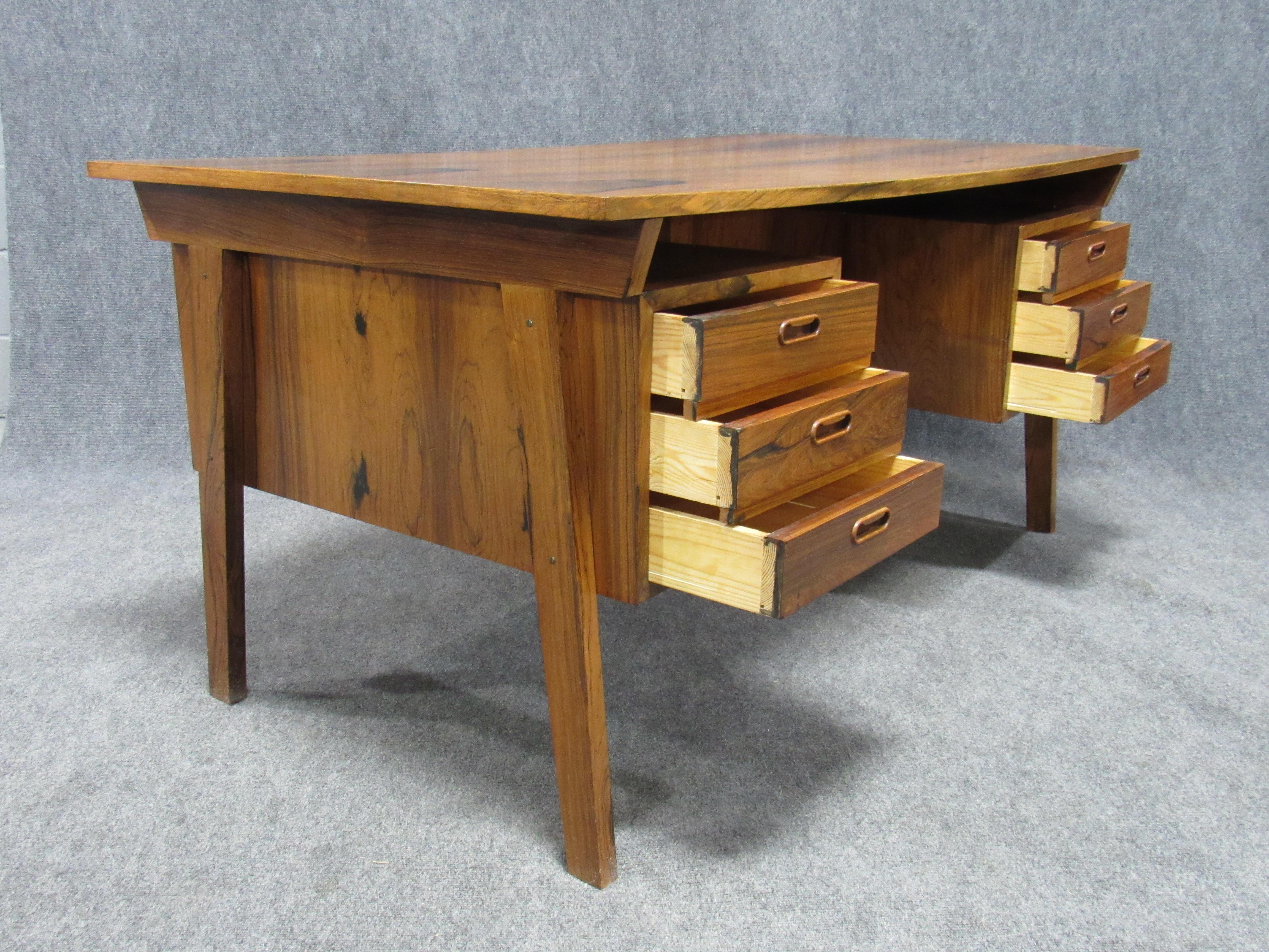 Midcentury Danish modern desk crafted in strikingly beautiful figured rosewood. Exquisitely crafted piece that will be the center piece of any home office, den or workplace. Piece in excellent vintage condition.