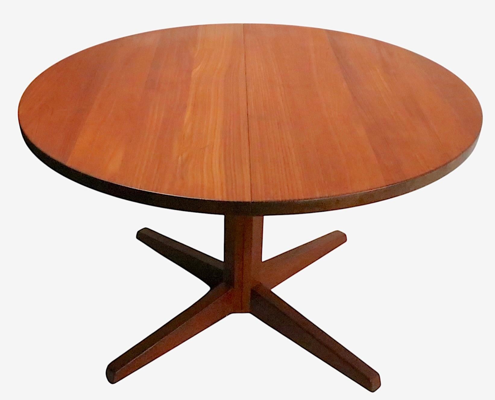 Chic, architectural Mid Century Danish Modern split pedestal dining table, with two original leaves. Designed by CJ Rosengaarden, made in Denmark, circa 1950's. The table is in good, clean, ready to use condition, the top has been refinished, the
