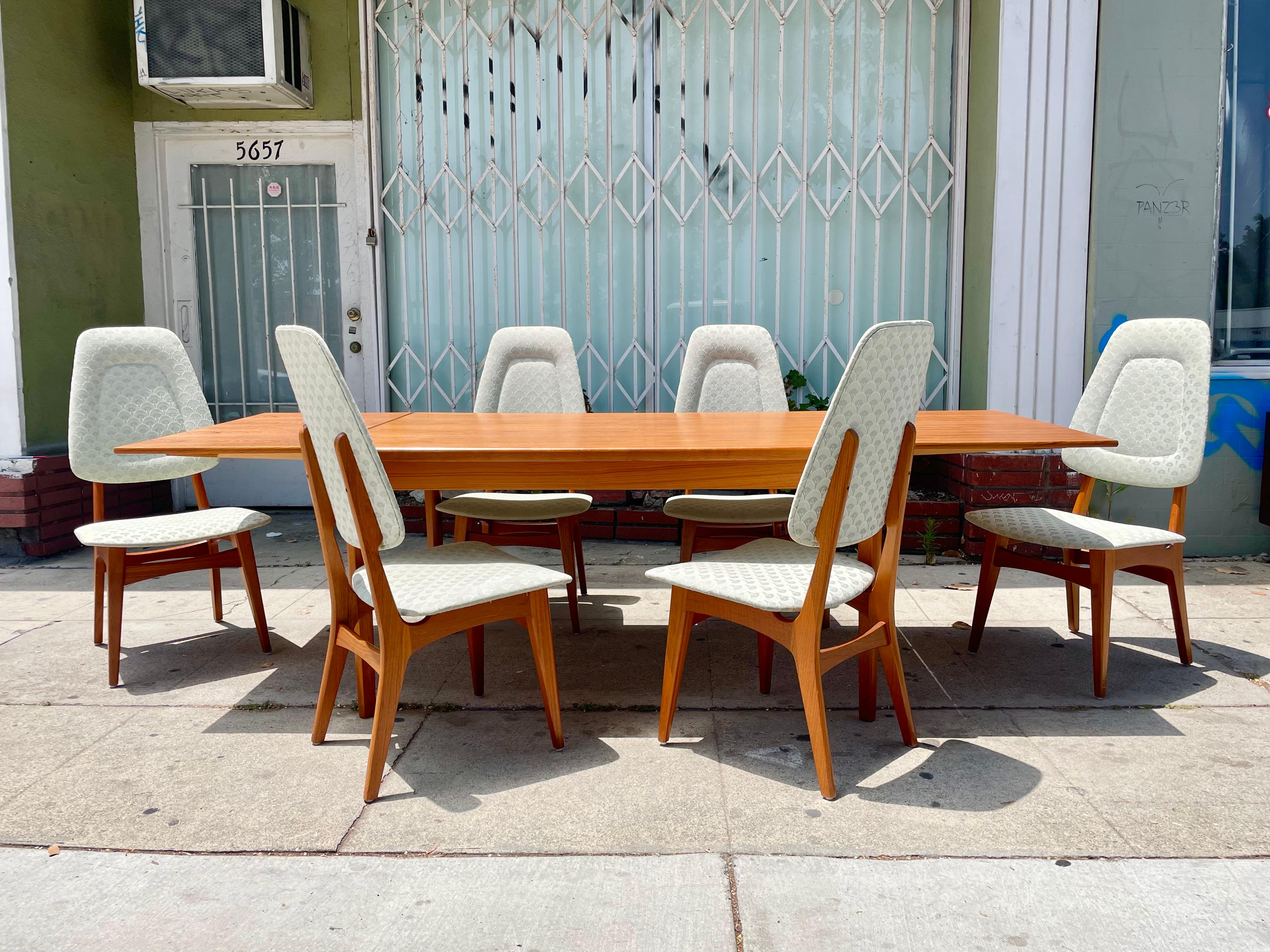 Danish modern extending teak dining set from Denmark, circa 1950s. This vintage dining table is built with the highest quality teak wood, where the aesthetic grains of teak stand out along the top and its extensions. If you want to expand the dining