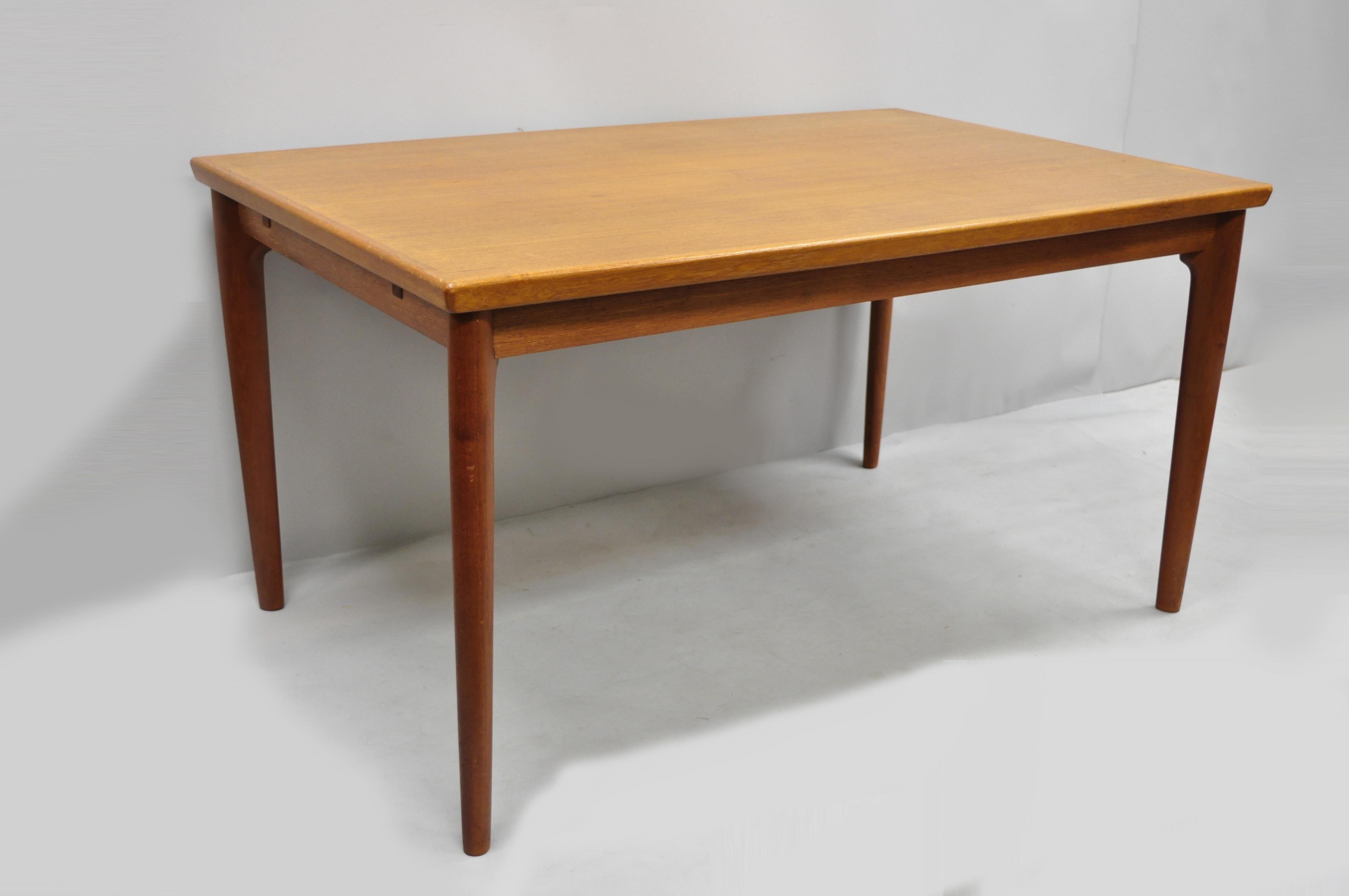 Mid century danish modern extending teak dining table. Item features 2 pull out extensions, beautiful wood grain, tapered legs, clean modernist lines, quality Danish craftsmanship, circa 1960s. Measurements: 29