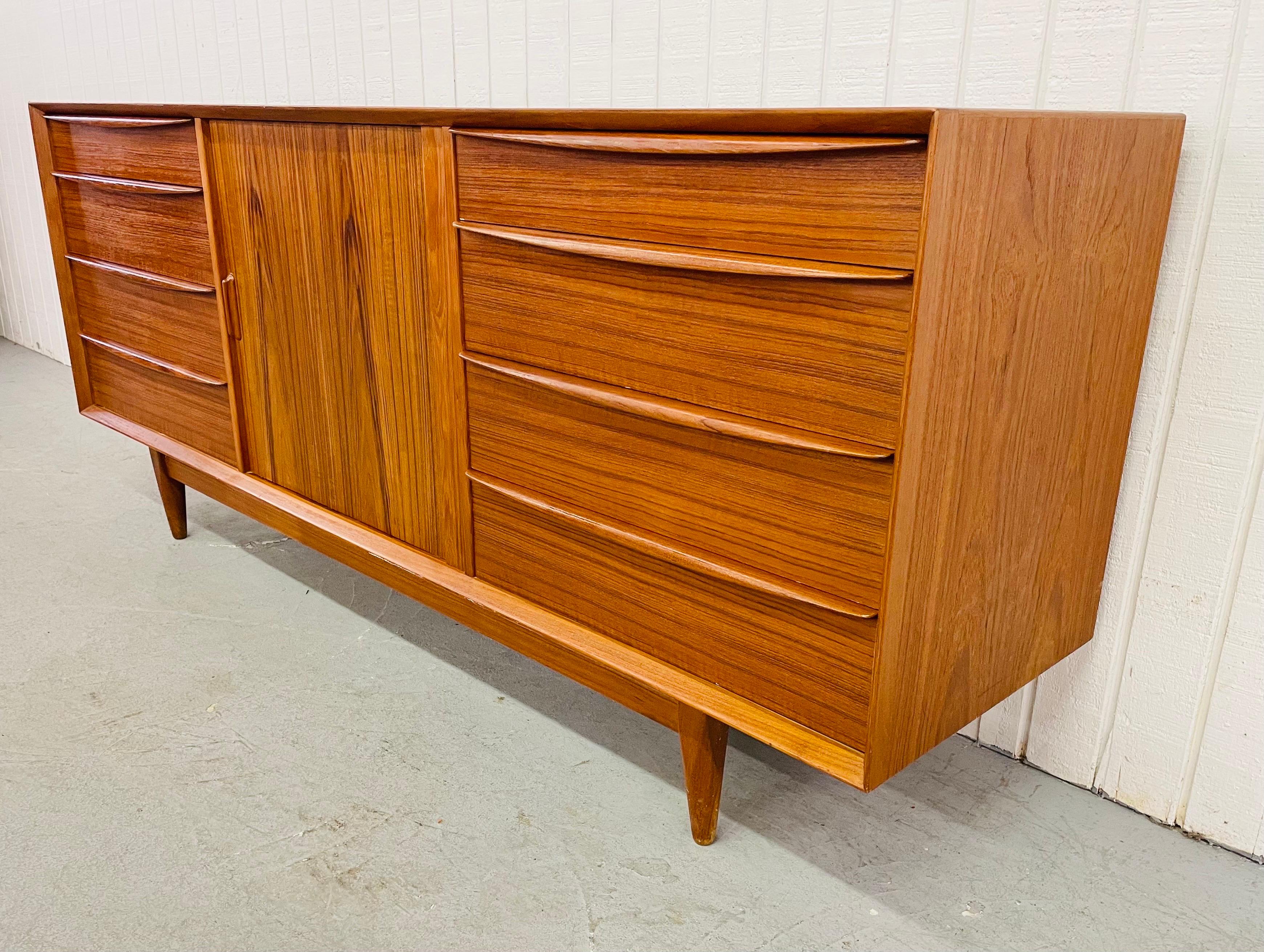 This listing is for an exceptional Mid-Century Danish Modern Falster Teak Tambour Dresser. Featuring four drawers on the left, four drawers on the right, a tambour sliding center door that opens up to five hidden drawers, and a beautiful teak finish.