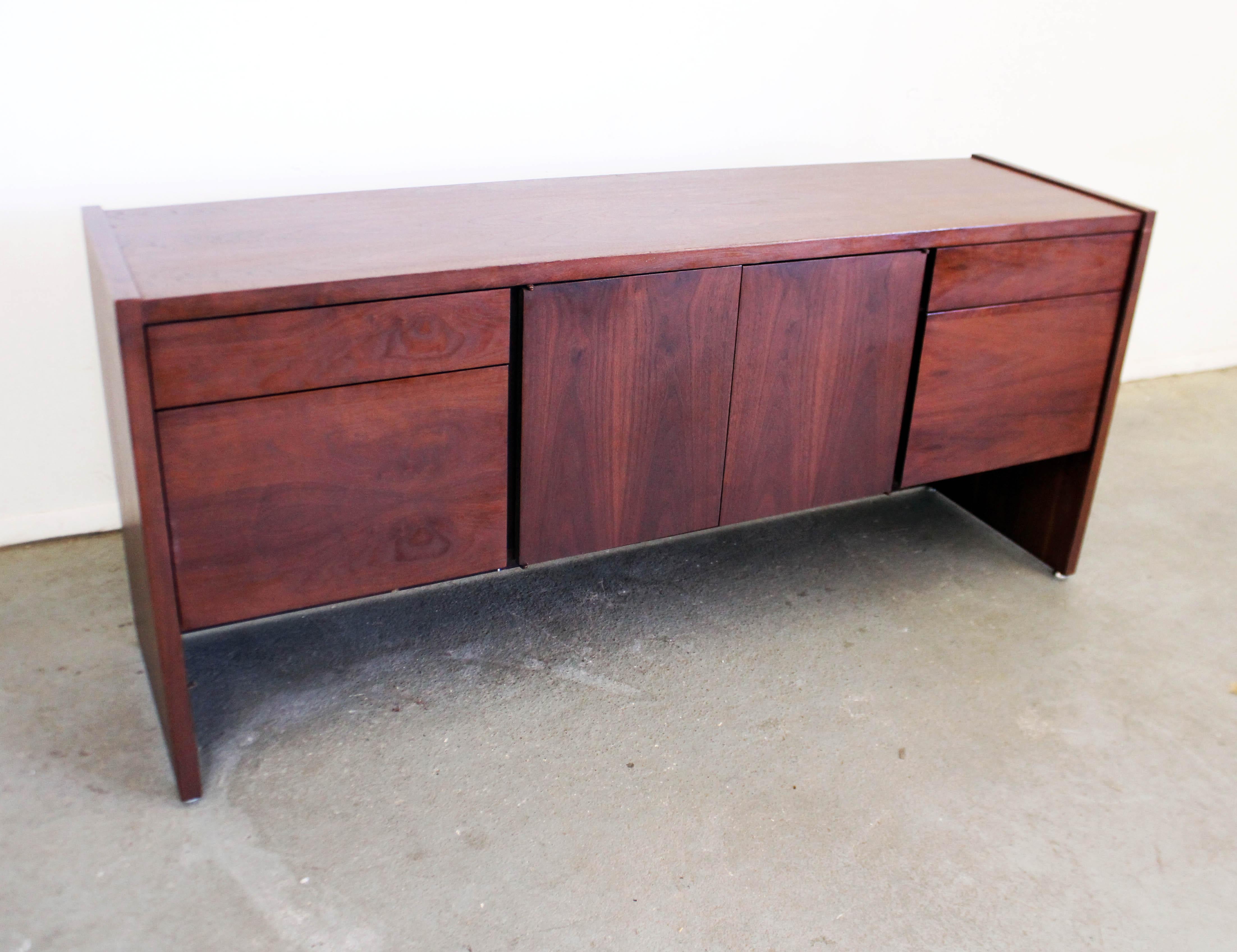 Offered is a vintage Mid-Century Modern credenza by Gunlocke. Looks to be walnut. Features four drawers with hidden pulls, metal tracks, and two center doors with inner adjustable shelving. Includes two file drawers with metal inserts. Overall, in