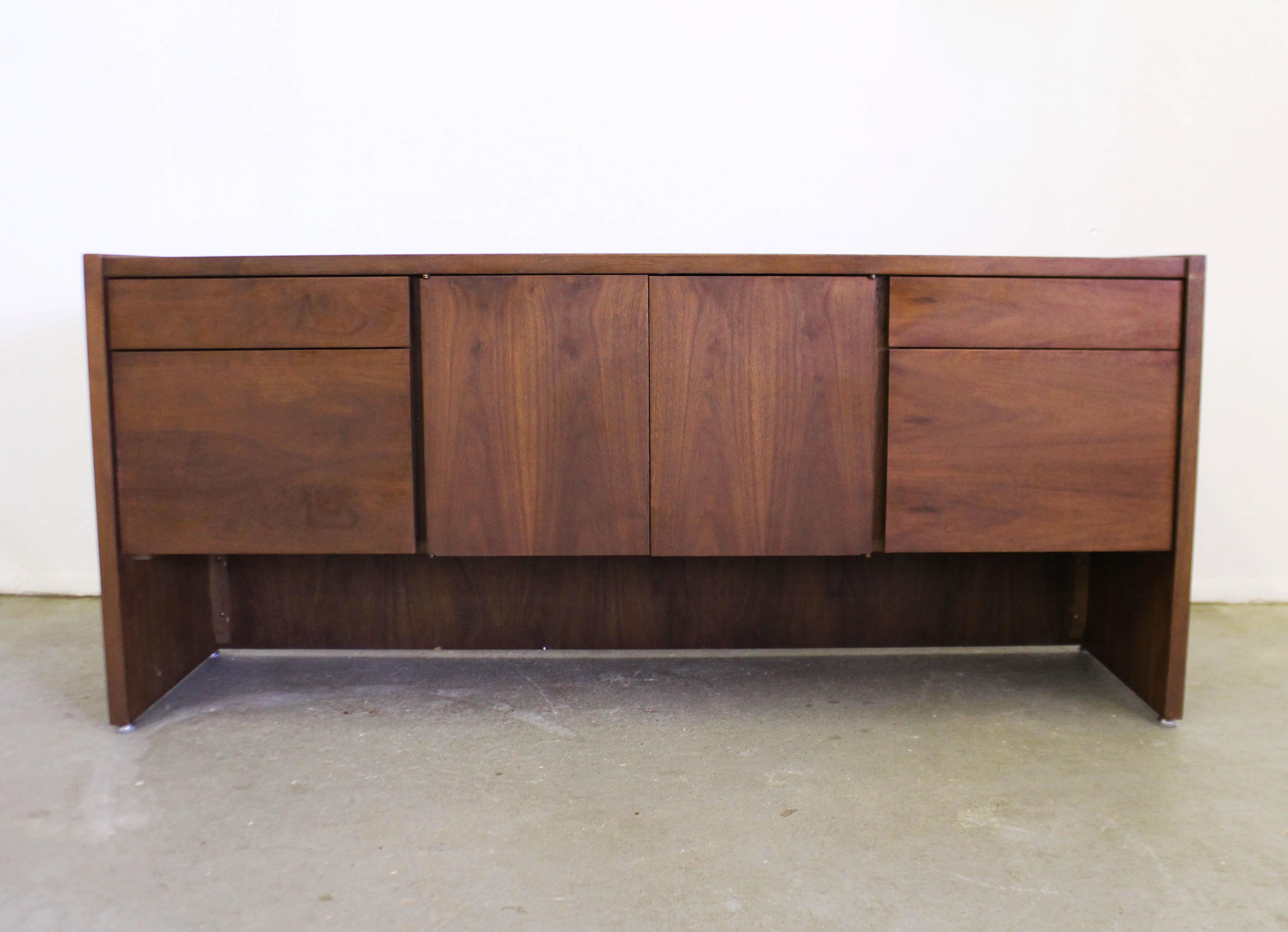 Offered is a vintage Mid-Century Modern credenza by Gunlocke. Looks to be walnut. Features four drawers with hidden pulls, metal tracks, and two center doors with inner adjustable shelving. Includes two file drawers with metal inserts. Overall, in