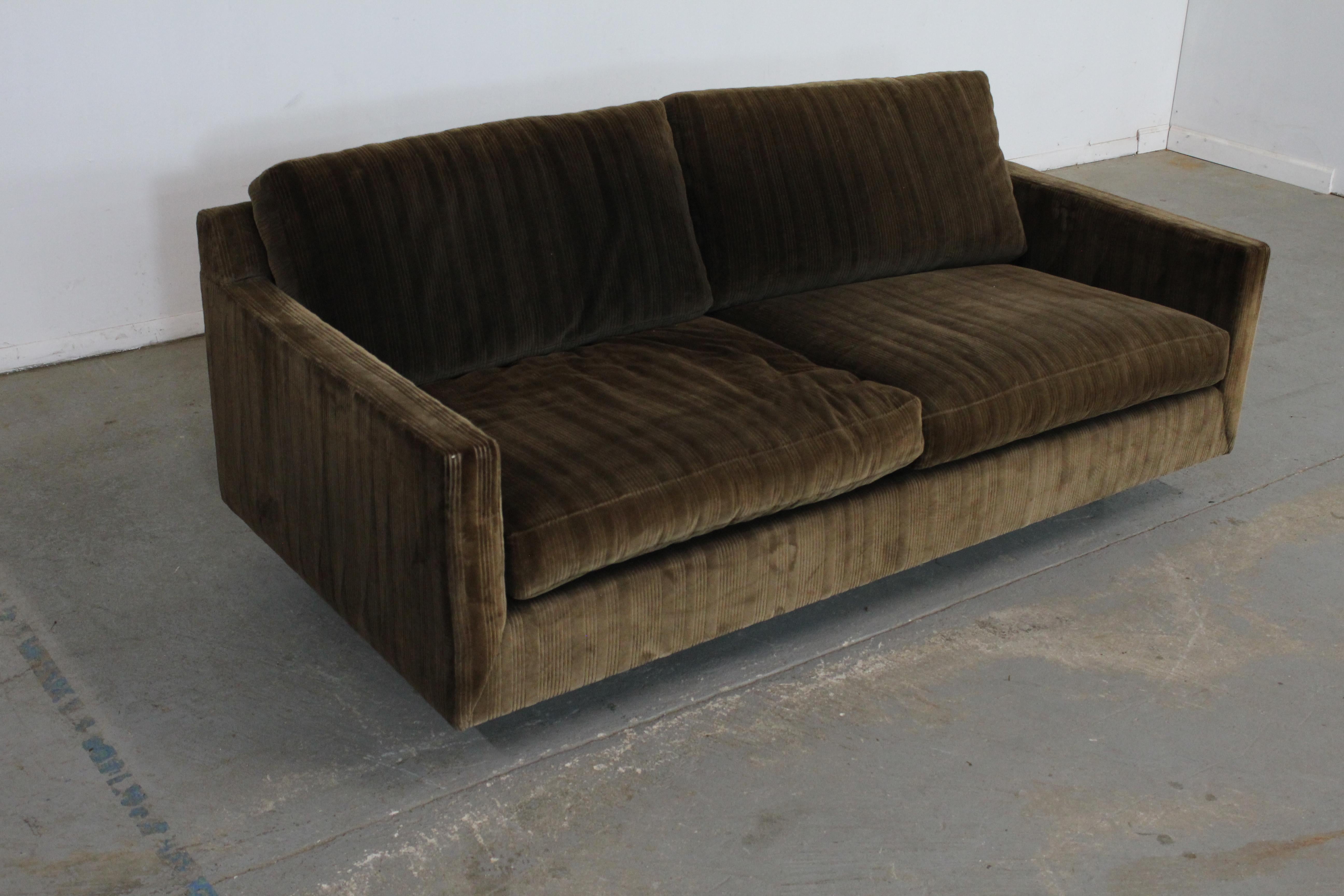 Offered is a vintage Mid-Century Modern sofa similar to the style of Milo Baughman, made by Stratford Designs. This is a three-seat sofa with sleek, modern lines. It is in good vintage condition with some age wear and fading on the upholstery, but