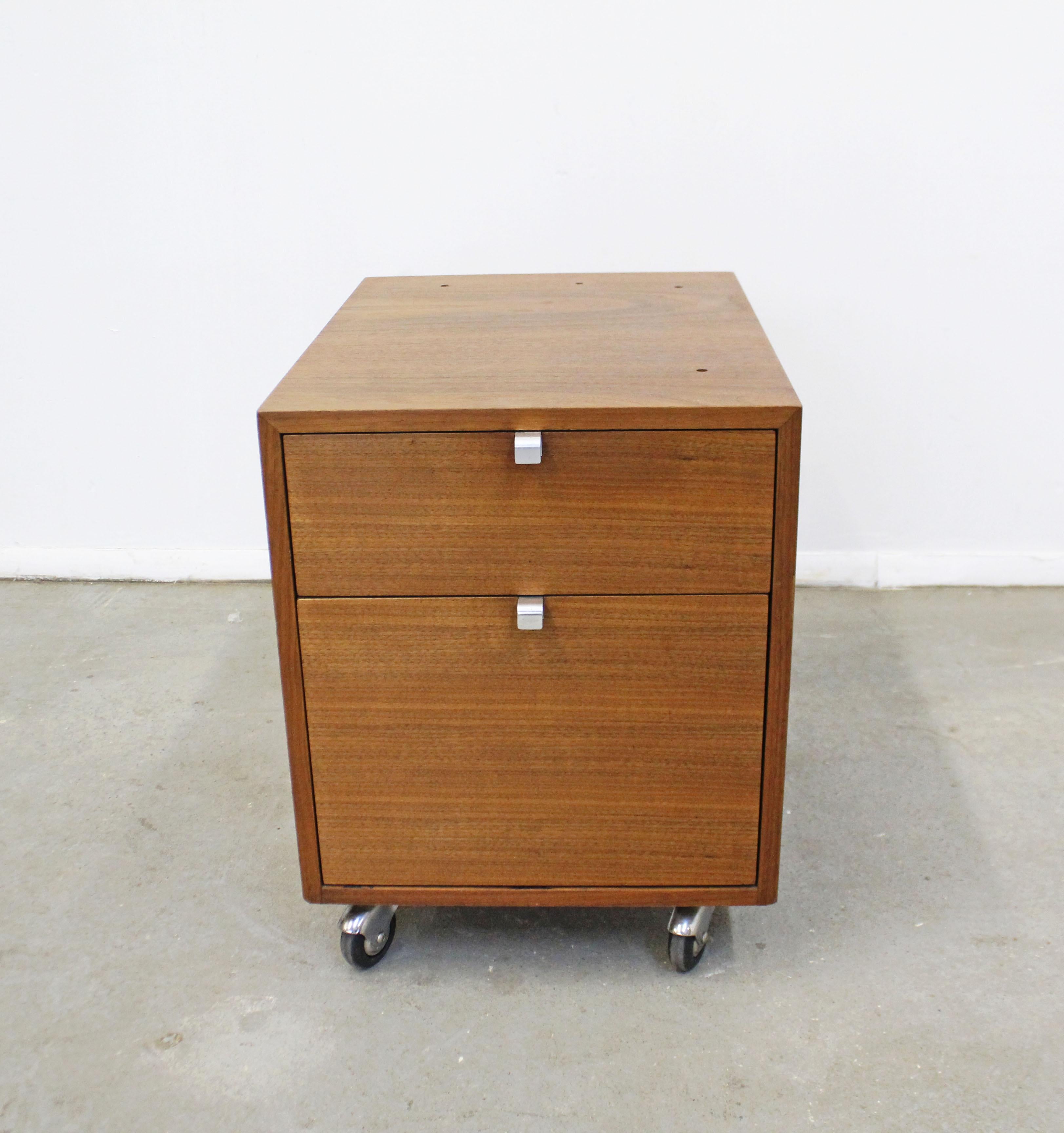 What a find. Offered is a vintage Mid-Century Modern file cabinet made by George Nelson for Herman Miller's iconic Comprehensive Storage Systems line. This piece is made of wood with two drawers, a side lock, and is on wheels. Has a lock for which