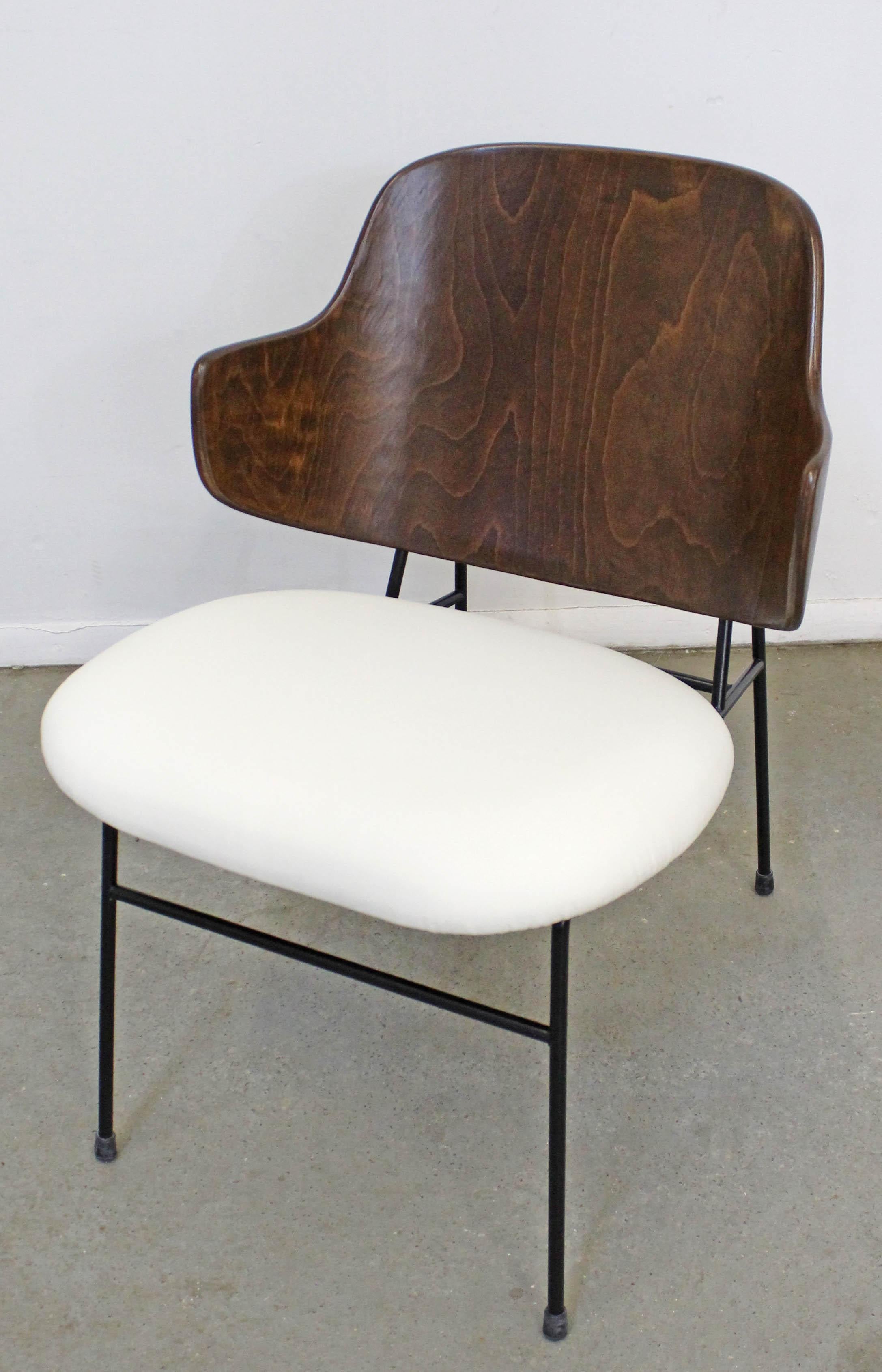 What a find. Offered is an original 'Penguin' chair designed by IB Kofod Larsen for Selig. This piece was designed in 1953 and had a limited production through the 1960s. It has been completely restored with a refinished walnut back, reupholstered