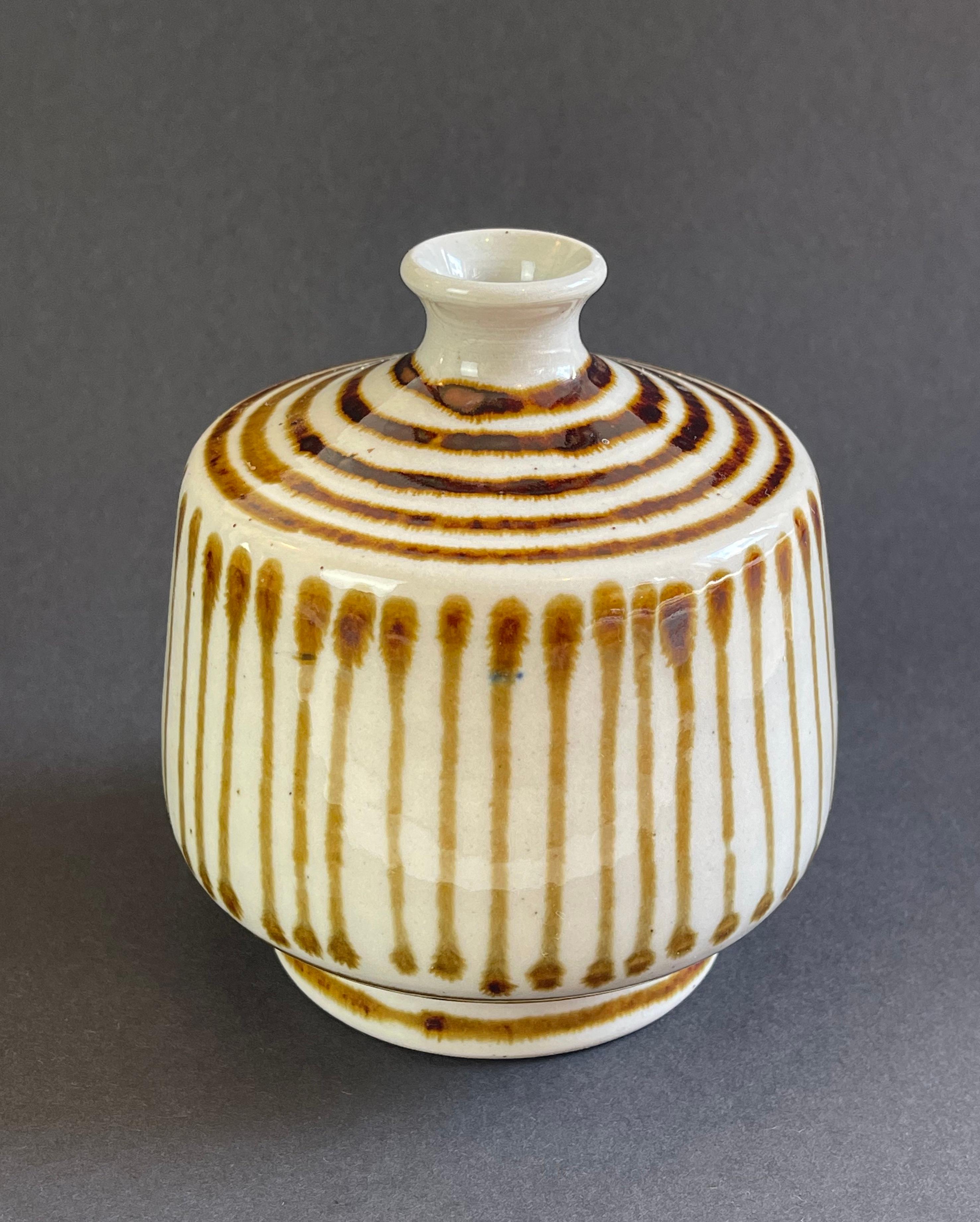 Of possibly Danish origin is this vase, hand made & hand painted ceramic vase.
Beautiful caramel coloured stripes on the natural beige base material.
Also with a hint of Japanese style, this piece is a unique find.
Signed ''W'' & ''21''.