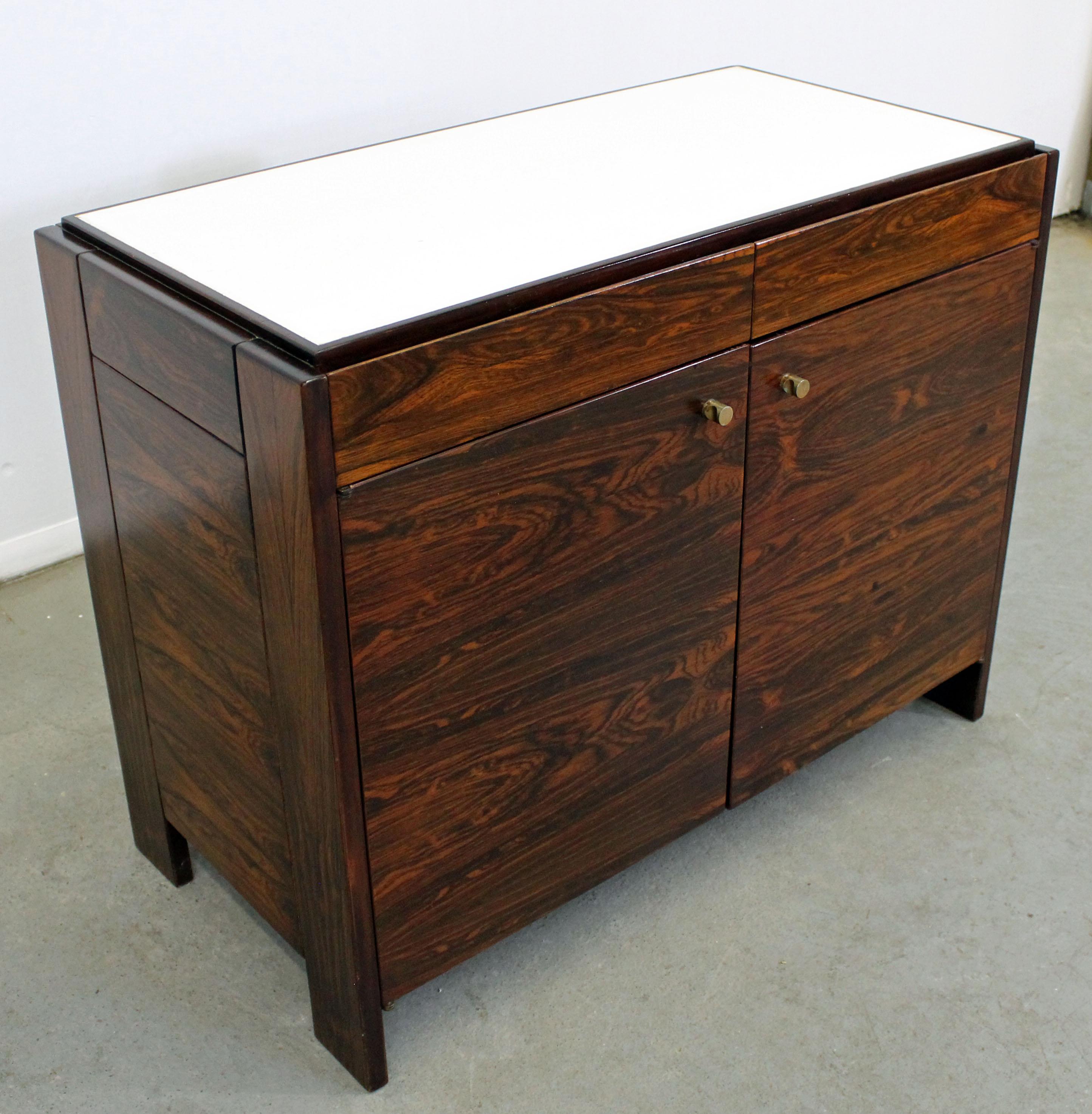 What a find. Offered is a gorgeous Mid-Century Modern rosewood server with a white laminate top by Knoll. This server features two drawers atop and two doors with adjustable shelving inside. It is in excellent condition for its age, shows some age