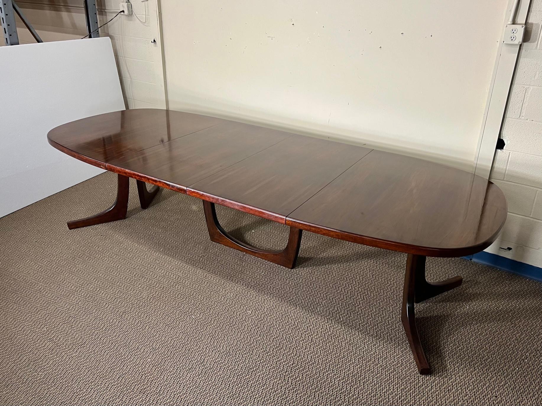 This is a large Danish rosewood dining table with 2 extension leaves. Very nice condition. Numerous light scratches in the laquer finish. Not all the way into the wood just in the finish. Had to move the table underneath some lights to make them