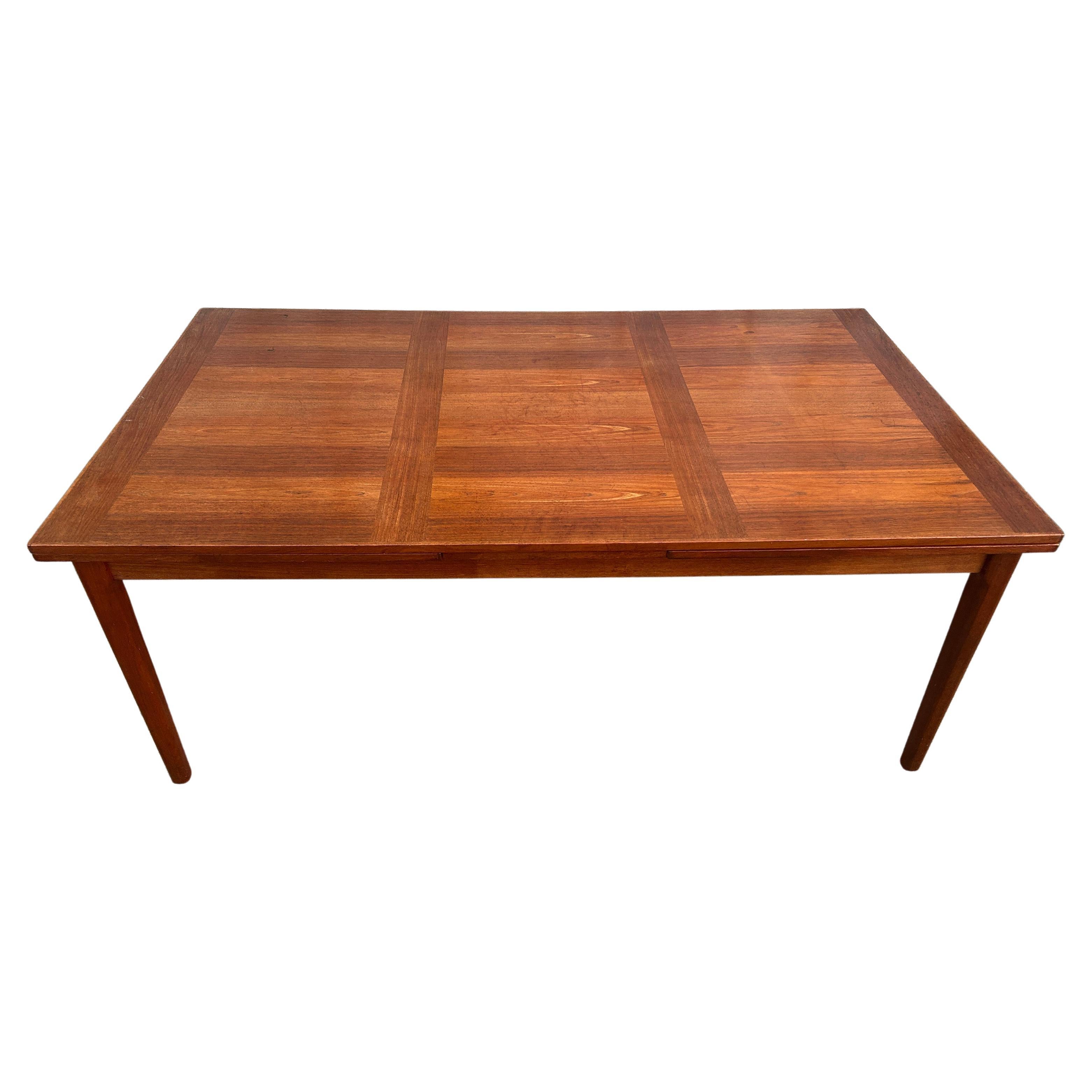 Mid century Danish modern teak extension dining table Denmark. Great Large Size Dining table with 2x 27” slide out hidden leaves. Rectangular design with solid teak rounded legs. Measures 72