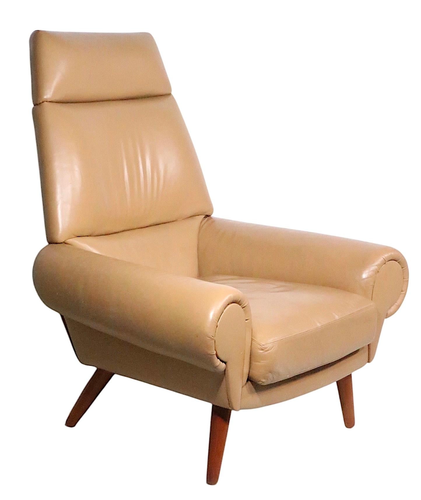 Eccezionale poltrona imbottita disegnata da Kurt Ostervig, per Ryesburg, realizzata in Danimarca intorno agli anni 1950/70. La sedia è di colore marrone chiaro,  o tan, con rivestimento in pelle, su gambe in teak a palo affusolate e distanziate. Lo