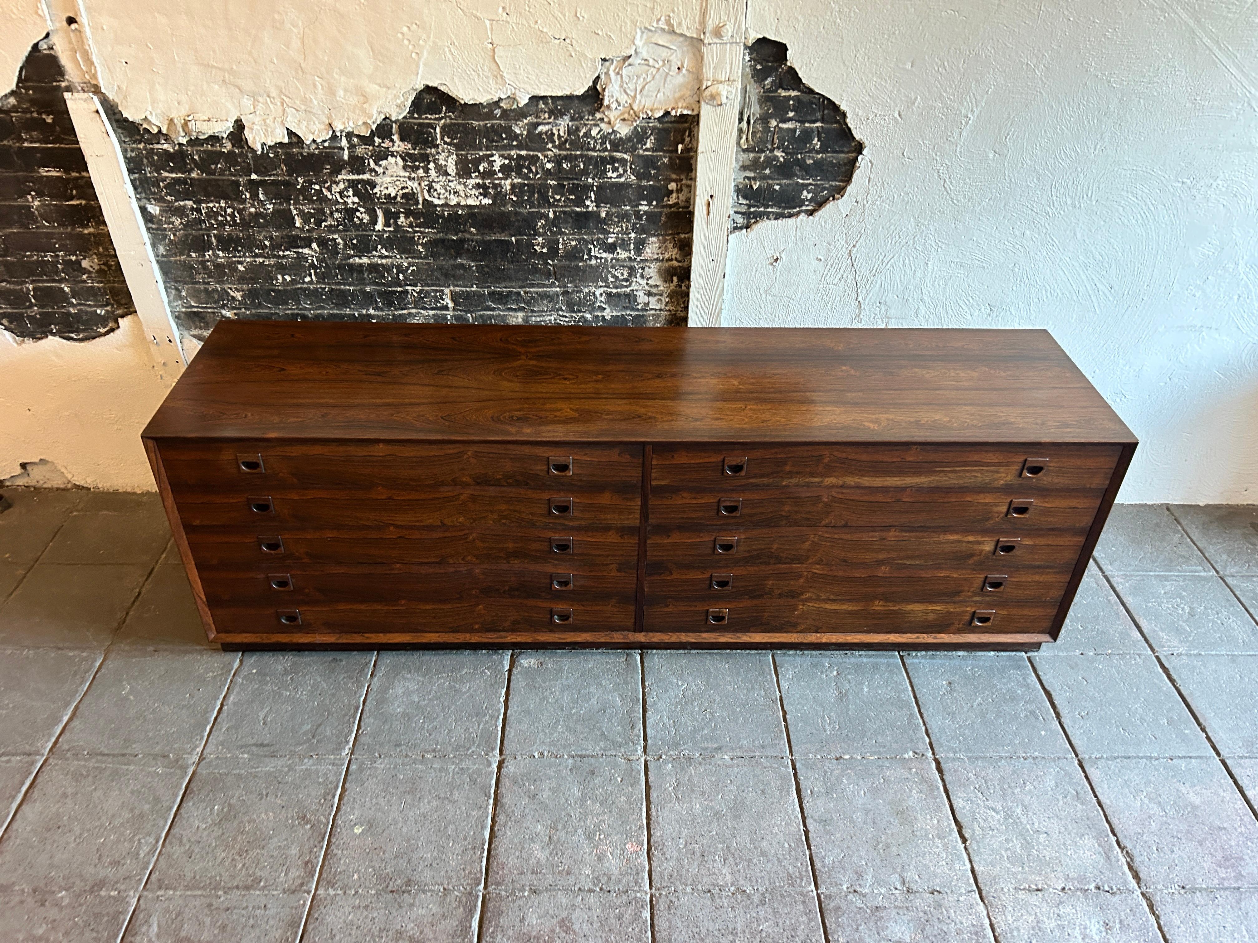 Beautiful mid-century long low Rosewood dresser credenza 8-drawer with beautiful carved finger pull handles. In the style of Arne Wahl Iversen. Has 6 upper shallow drawers and 2 lower deep drawers. Clean inside and out all drawers slide smooth on a