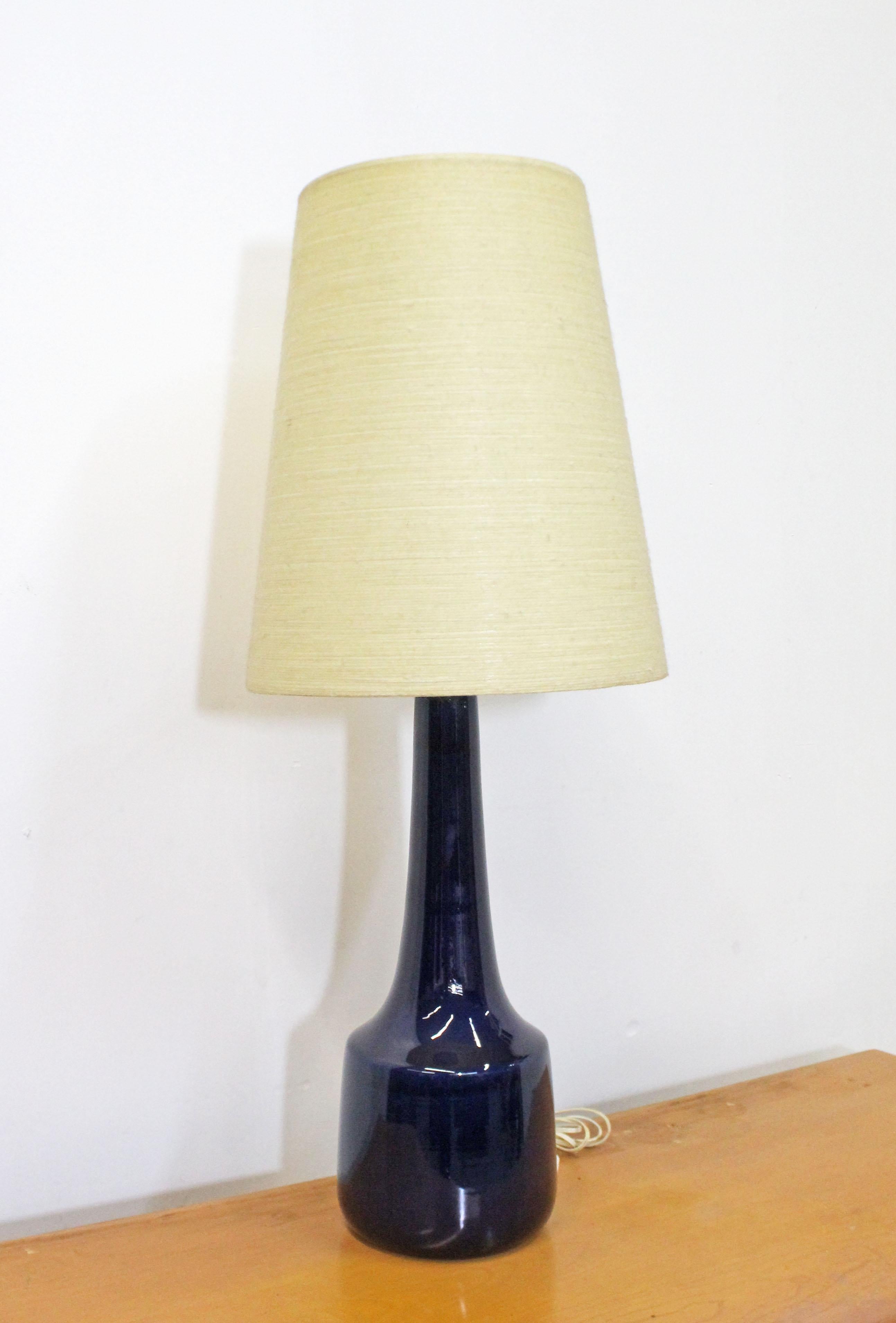 Offered is a gorgeous vintage table lamp by Lotte & Gunnar Bostlund. This lamp has a molded ceramic blue base and comes with its original fiberglass & string shade. It is in excellent vintage condition, has been tested and works. A great piece to