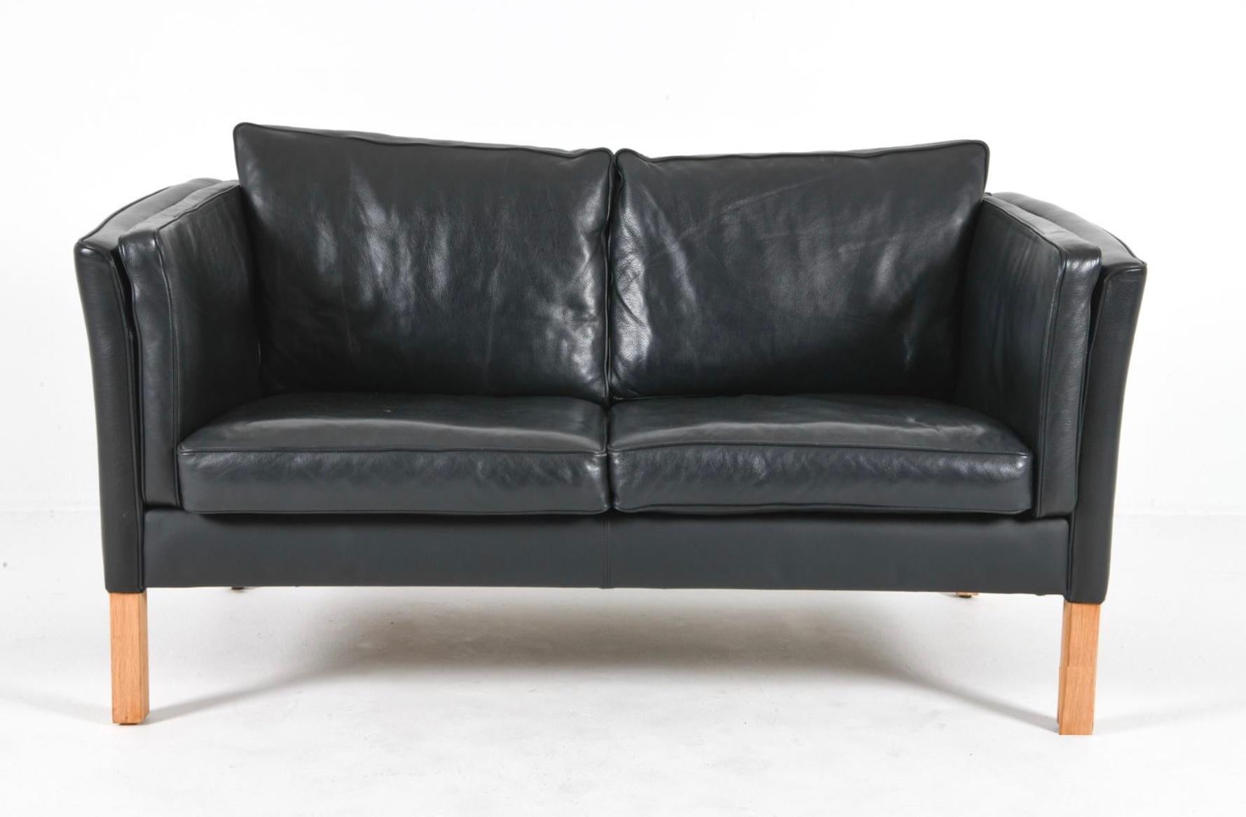 Mid Century Scandinavian modern Curved arm Low Mid century Danish modern Schwarzes Ledersofa mit 2 Sitzen und Beinen aus Birkenholz. Stil von Børge Mogensen. Schöne dicke schwarze Leder ist weich und zeigt wenig bis gar keine Gebrauchsspuren.