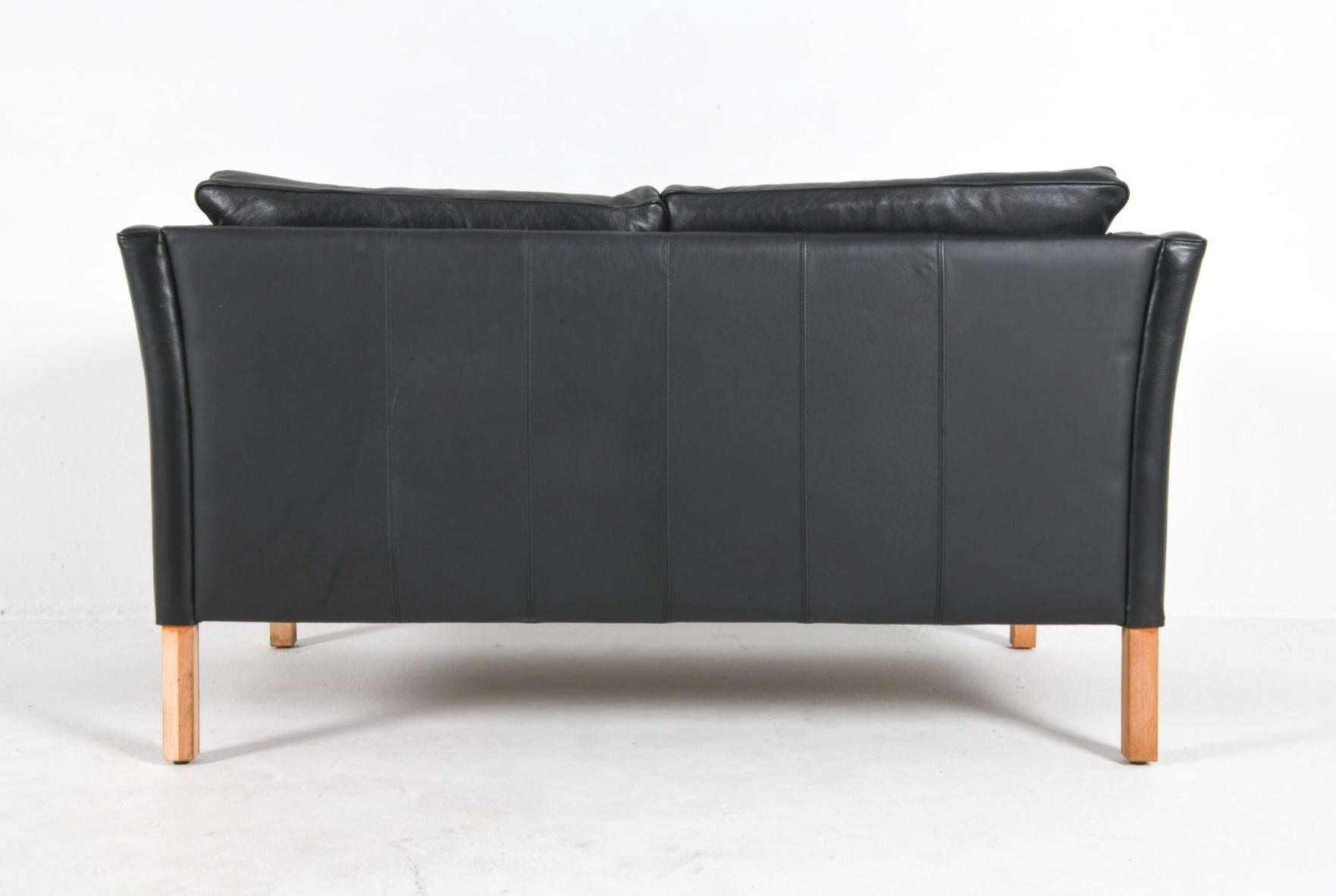Mid century Danish Modern Low Curved Arm Schwarzes Leder 2 Sitz Sofa Eiche Beine (Dänisch) im Angebot