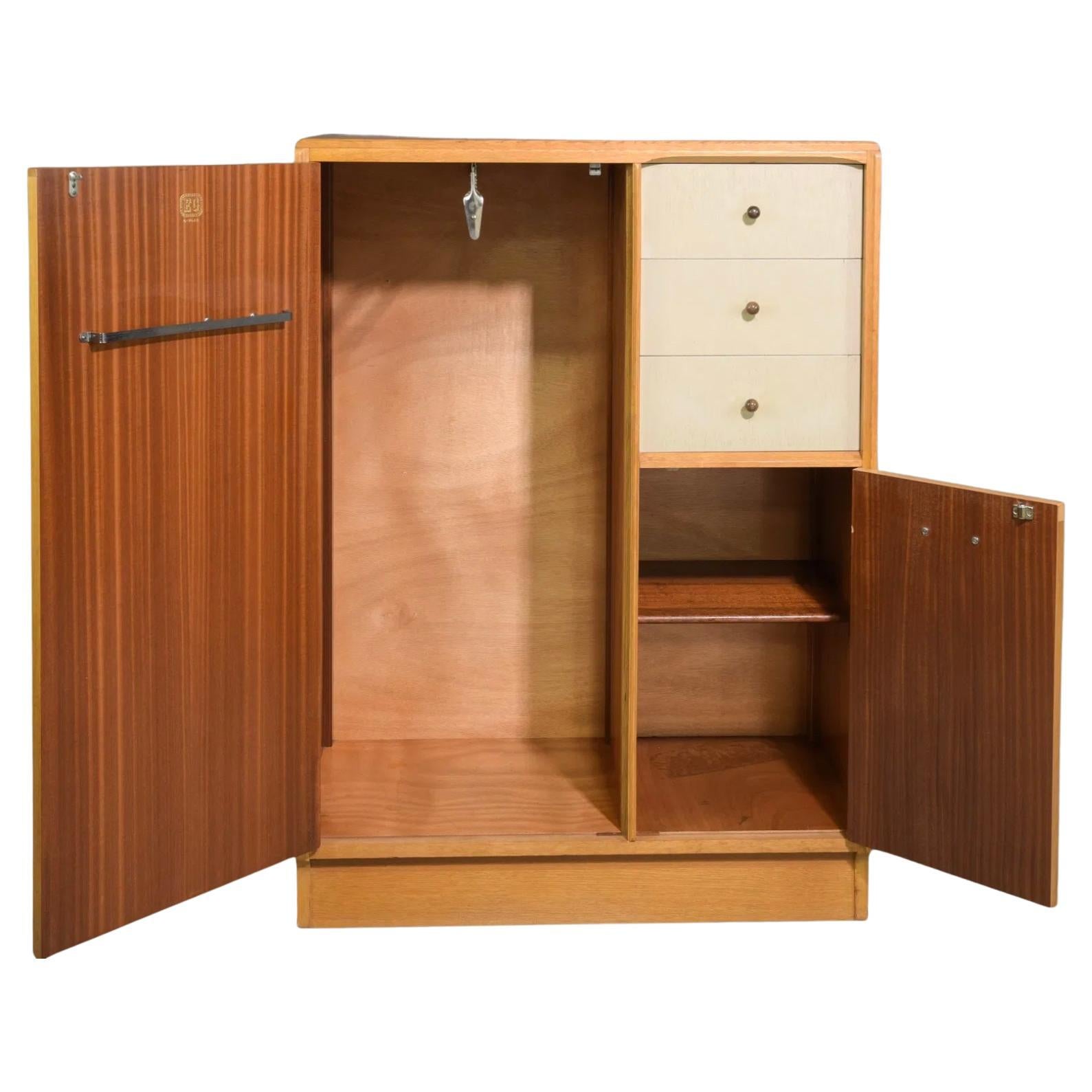 Mid-century modern teak niedrige garderobe schrank schrank. Hat 2 Vordertüren mit 3 Schubladen. Die linke Seite ist offen und mit einer Kleiderstange versehen. Hat Teakholz geritzte Griffe auf der Vorderseite. Helle Holzmaserung auf der Außenseite