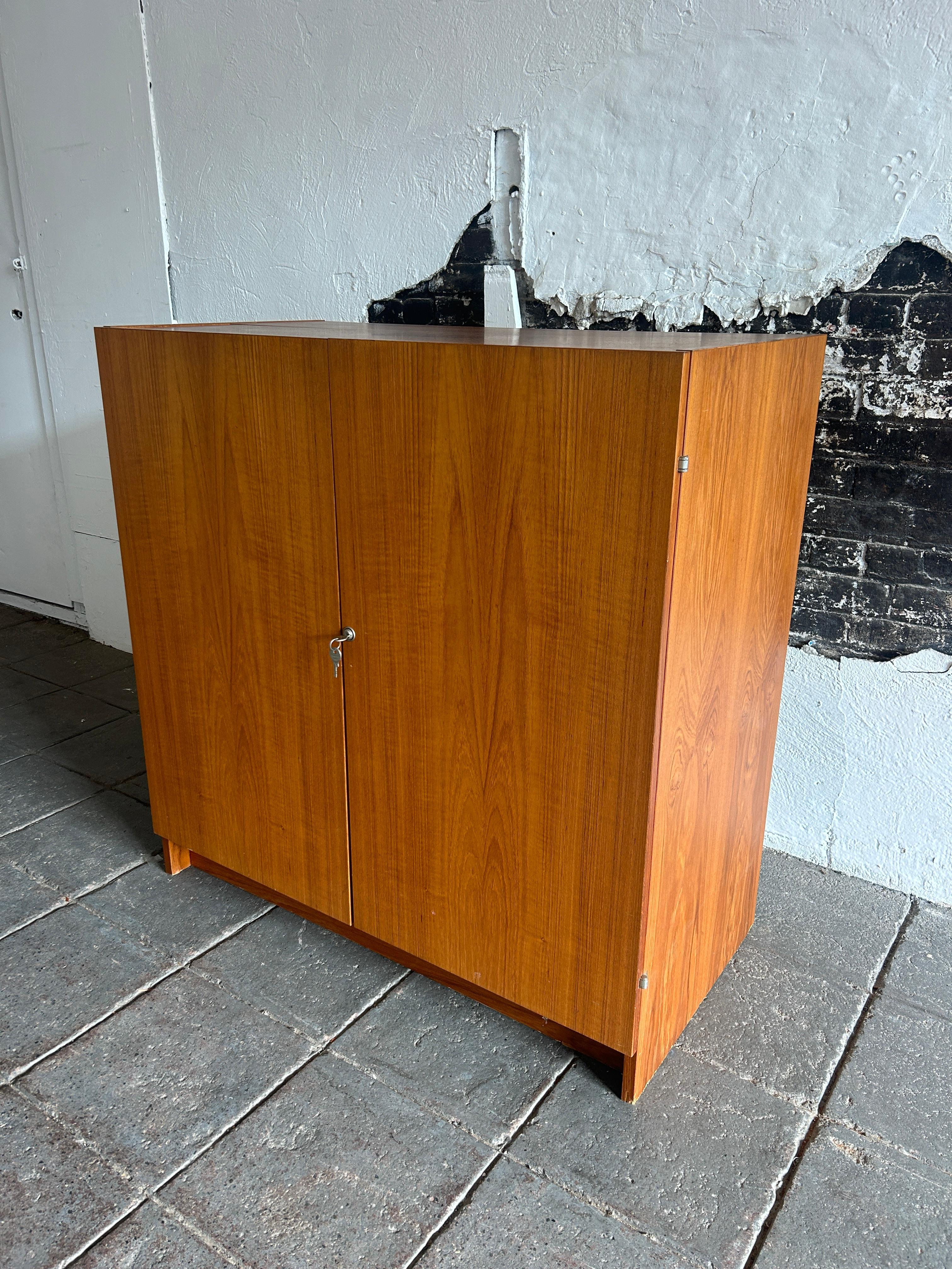 Mid century teak closable locking teak writing desk Similar to the Magic Box desk. The piece closes completely and can be key-locked to protect all your documents. Opened. This desk is completely original and in very good condition. The interior has