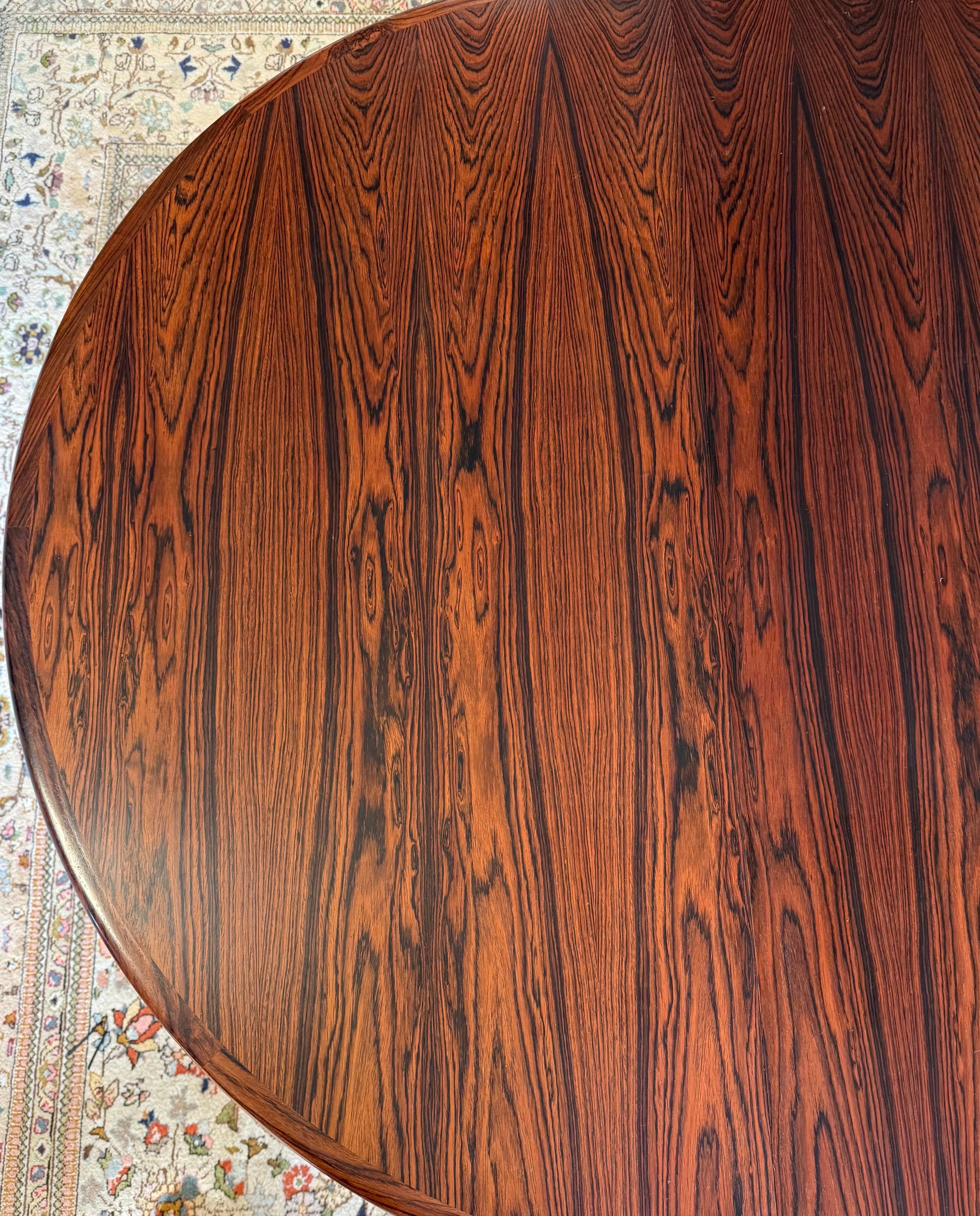 Stunning and iconic Niels Otto Moller rosewood expandable dining table.  The table has two leaves that make it oval shaped.  If both of the leaves are removed, the table becomes 47