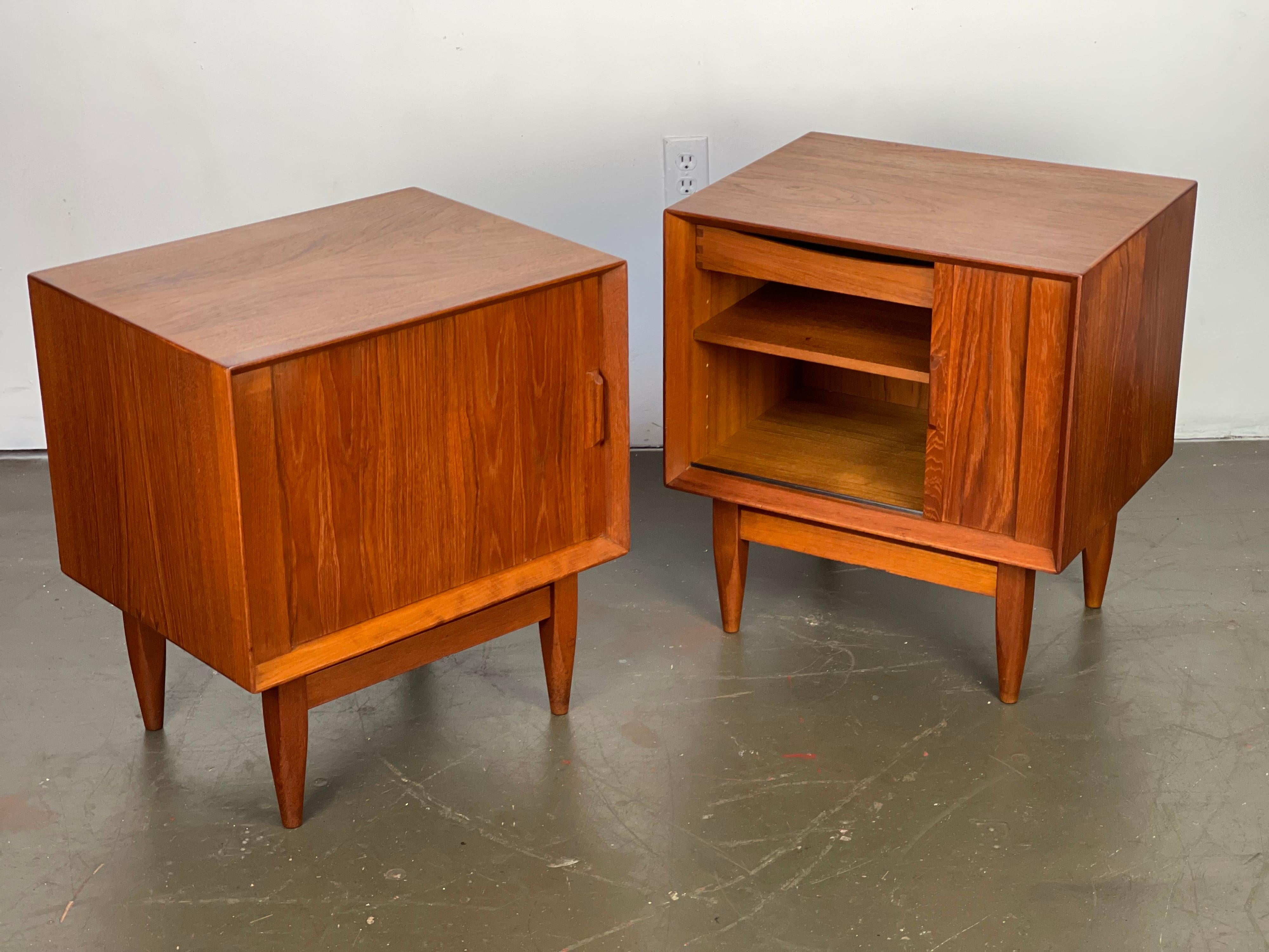 Classic set of early Danish Modern teak nightstands by Svend Madsen for Falster Moberlfrabrik of Denmark; featuring rolling tambour doors, adjustable shelves and adjustable drawers. These are great nightstands - these are early ones with the nice