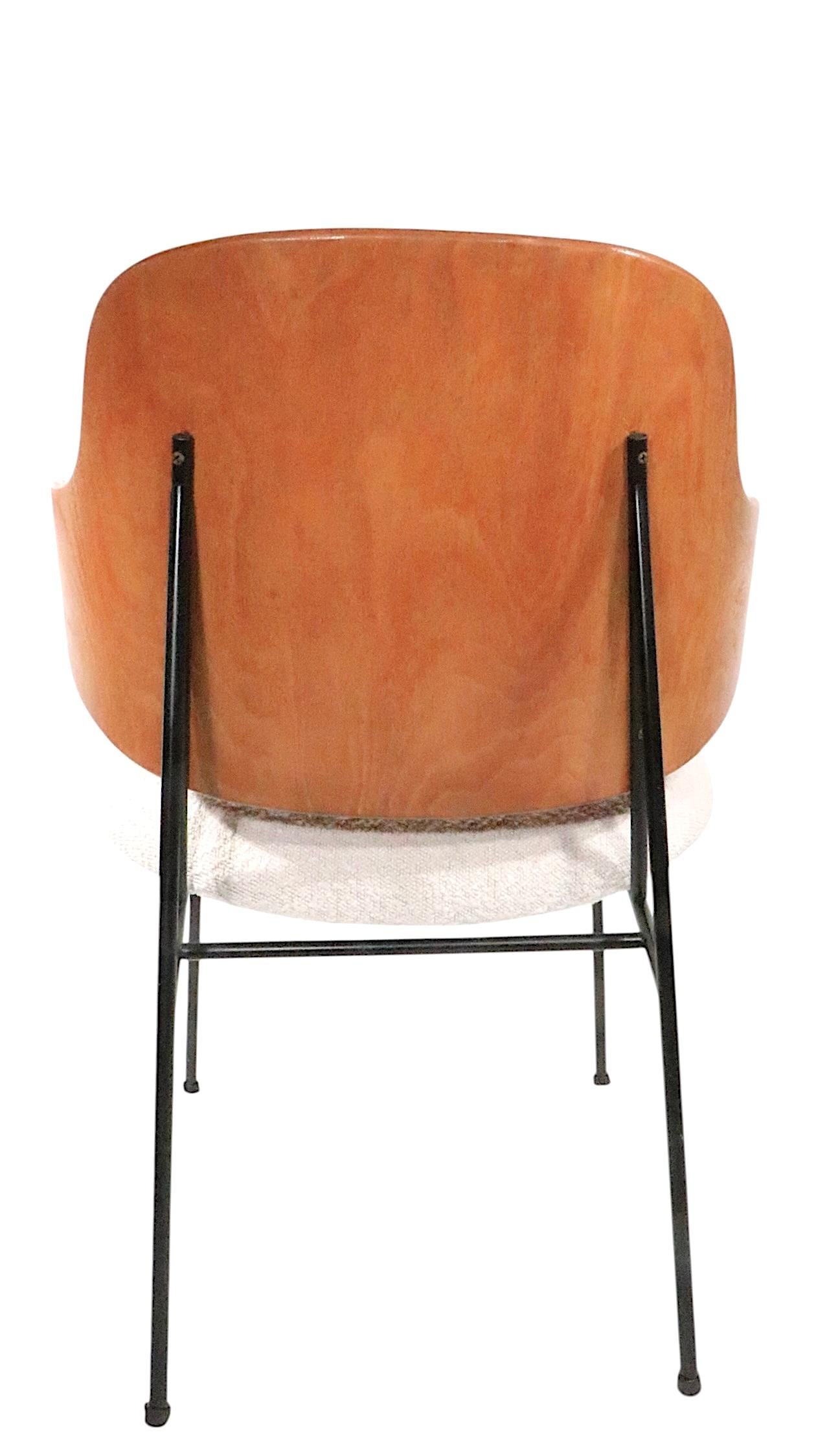 Tumbona icónica Pingüino, fabricada por Kofod - Larsen, distribuida por Selig. La silla tiene un armazón de hierro forjado, un asiento acolchado recién tapizado ( Boucle ) y un respaldo de madera contrachapada esculpida. Este ejemplar está en