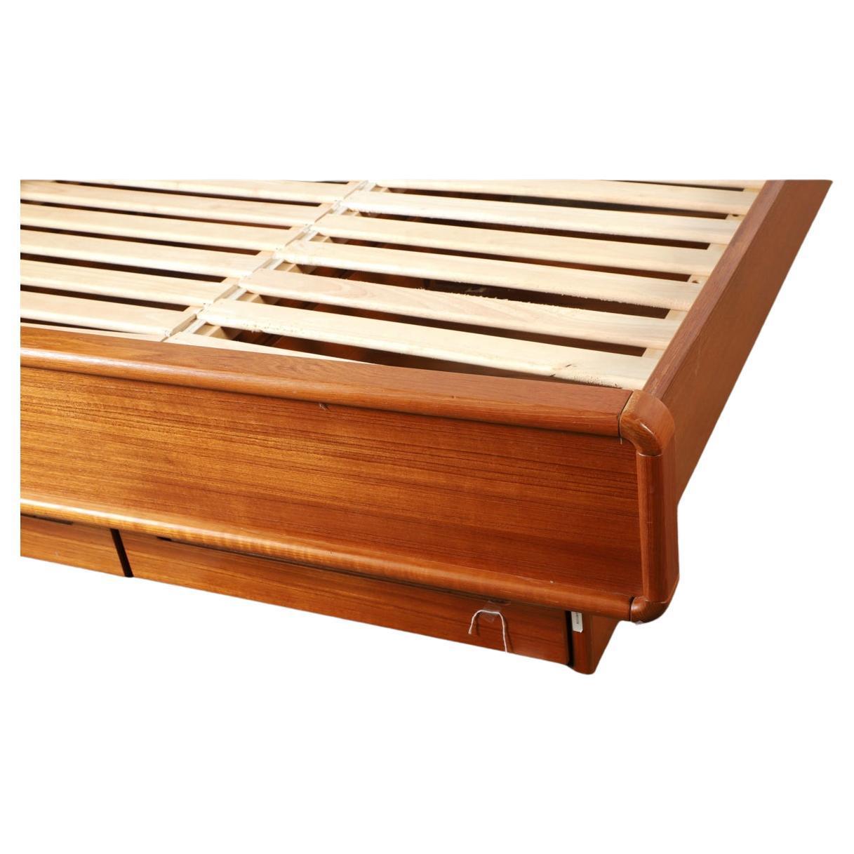 Stunning Mid century Danish Modern Teak Platform Queen Size Bed. Beautiful Platform bed that sits on a platform base. It has (2) top teak flip up doors in the headboard for Blanket or pillow storage. Has solid wood slats and teak sides and