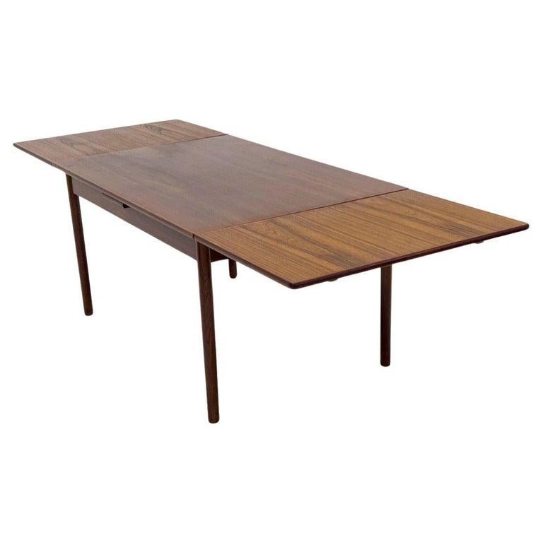 Table de salle à manger à rallonge en teck du milieu du siècle dernier Belle table en teck brun foncé à rallonge avec (2) rallonges gigognes. Les feuilles sont munies de poignées sculptées sous la feuille pour les retirer. Pieds ronds en teck massif