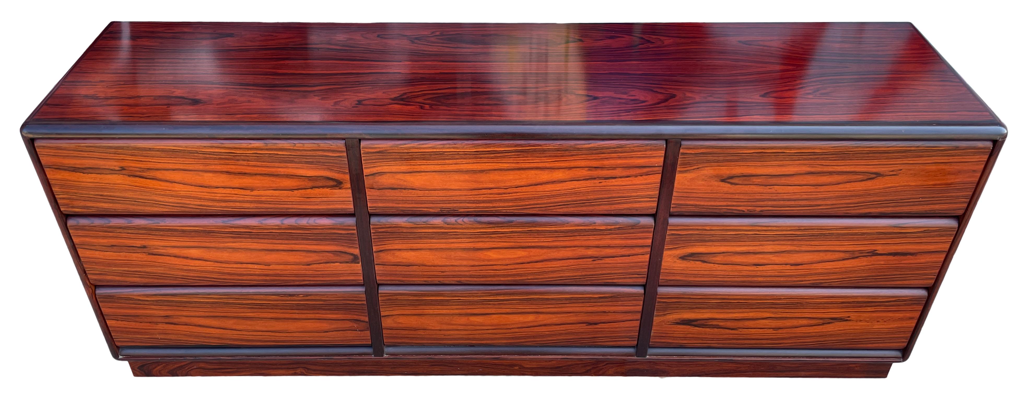 Very clean mid-century Danish modern rosewood 9 drawer credenza or dresser. All drawers slide smooth on metal glides. Beautiful Rosewood grain. Rounded corners on a rosewood base. Made In Denmark labeled Brouer Mobler. Located in Brooklyn