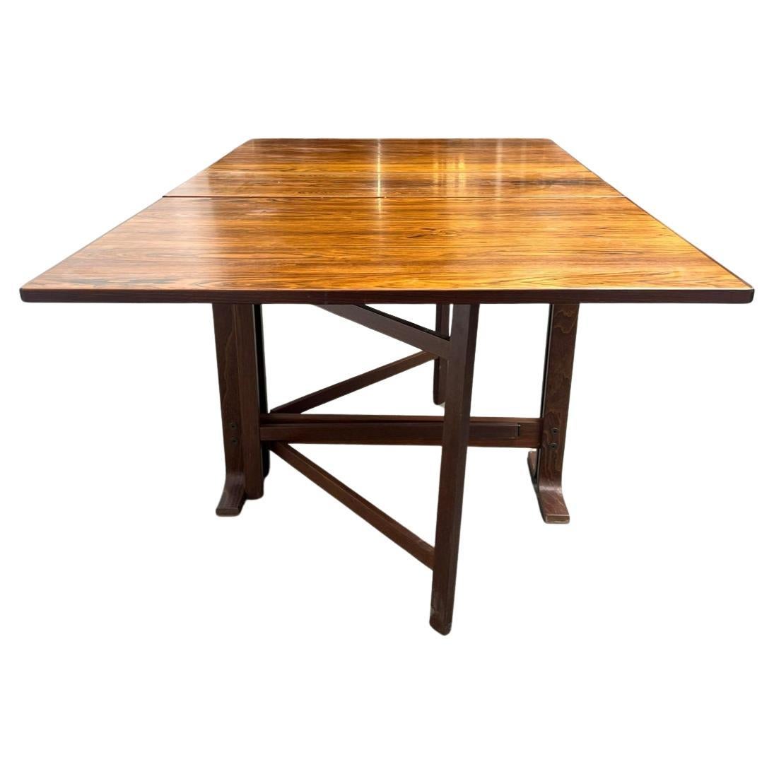 Table de salle à manger pliante en bois de rose, style Bruno Mathsson, modernité danoise du milieu du siècle dernier. Dispose de (2) feuilles tombantes et se replie de manière compacte. La table entièrement ouverte mesure 59