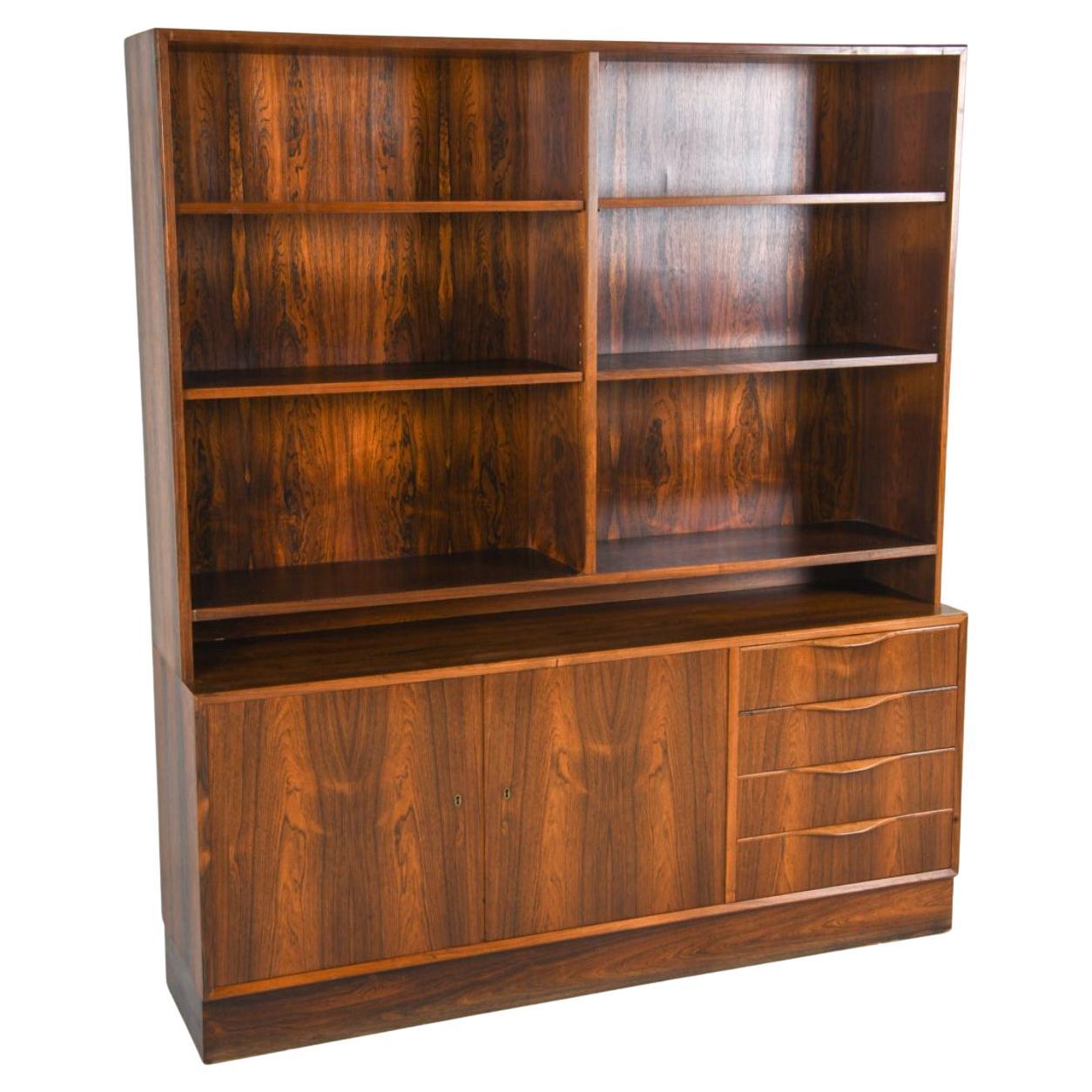 Credenza alta in legno di palissandro con libreria del metà secolo danese ha Key. Credenza inferiore a (2) ante con (4) cassetti, l'altro lato è dotato di ripiani regolabili. La libreria pensile alta in alto è dotata di scaffali. Poggia su una base