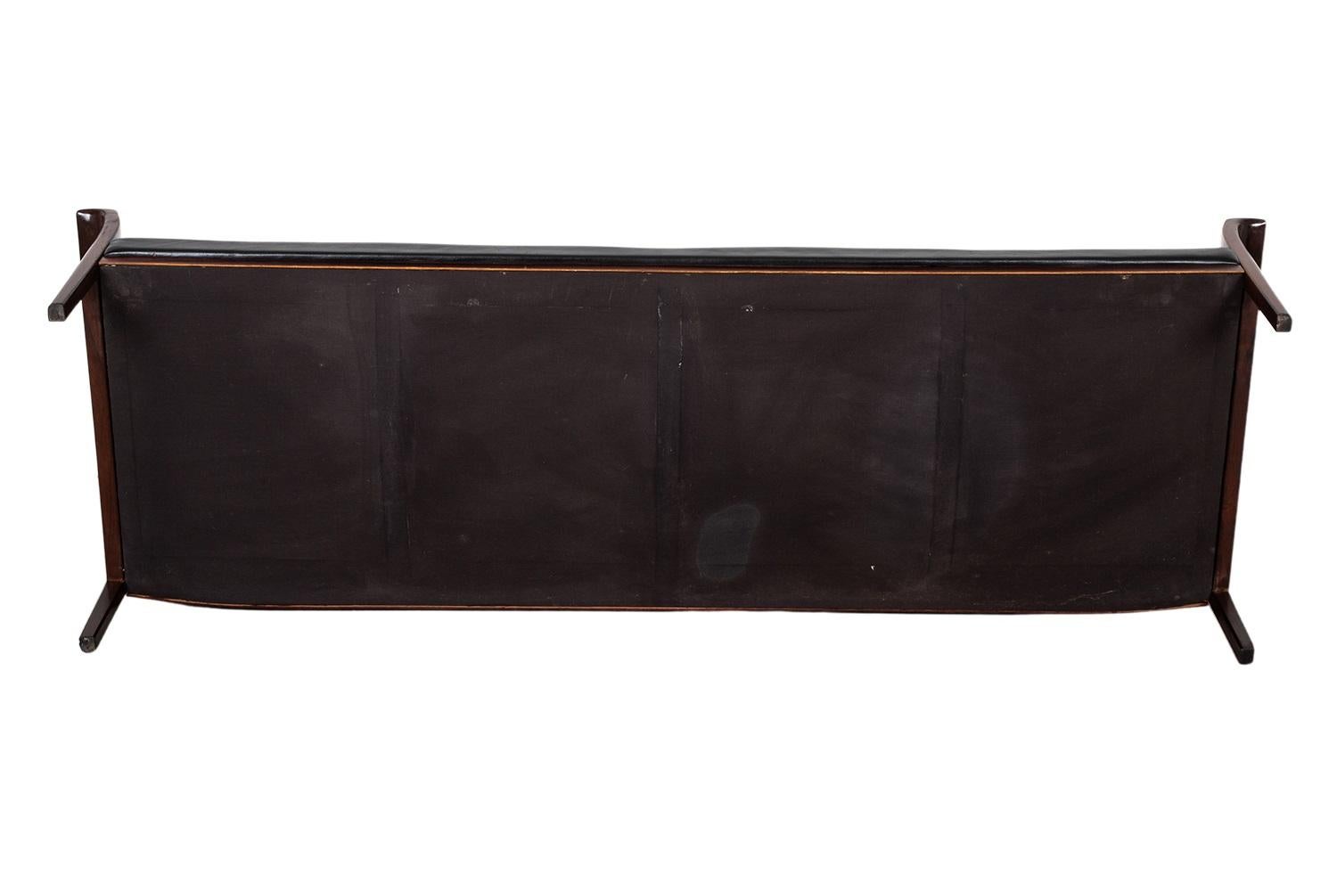 Hans Olsen Sofa: Original Black Leather & Rosewood elegance. Discover the sophistication of the Hans Olsen Sofa, a mid-century masterpiece crafted in the 1960s. Featuring original black leather upholstery and a warm rosewood frame, this stunning