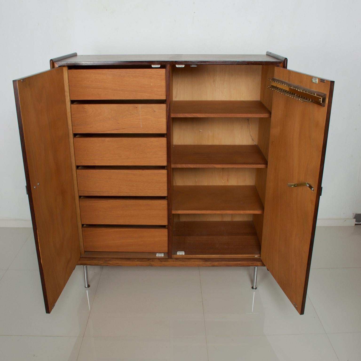 We are pleased to offer for your consideration a mid-century danish modern highboy in Rosewood with teak drawers. Mounted on chrome-plated legs. The doors open with ease. Sculptural chrome-plated handles. Made in Denmark circa late 1960s.